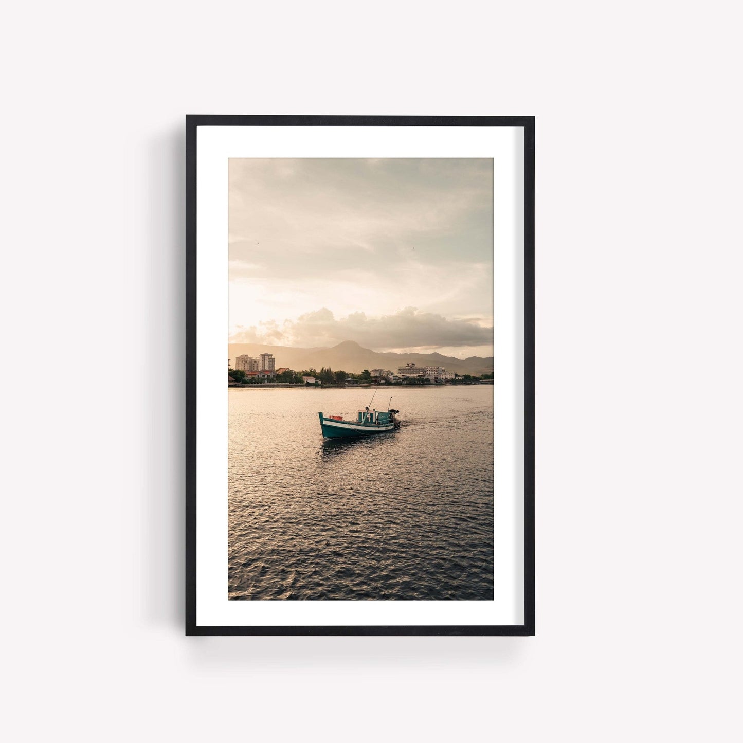 Framed Kampot Boat photo featuring a lone boat on calm water with city and mountains in the background.