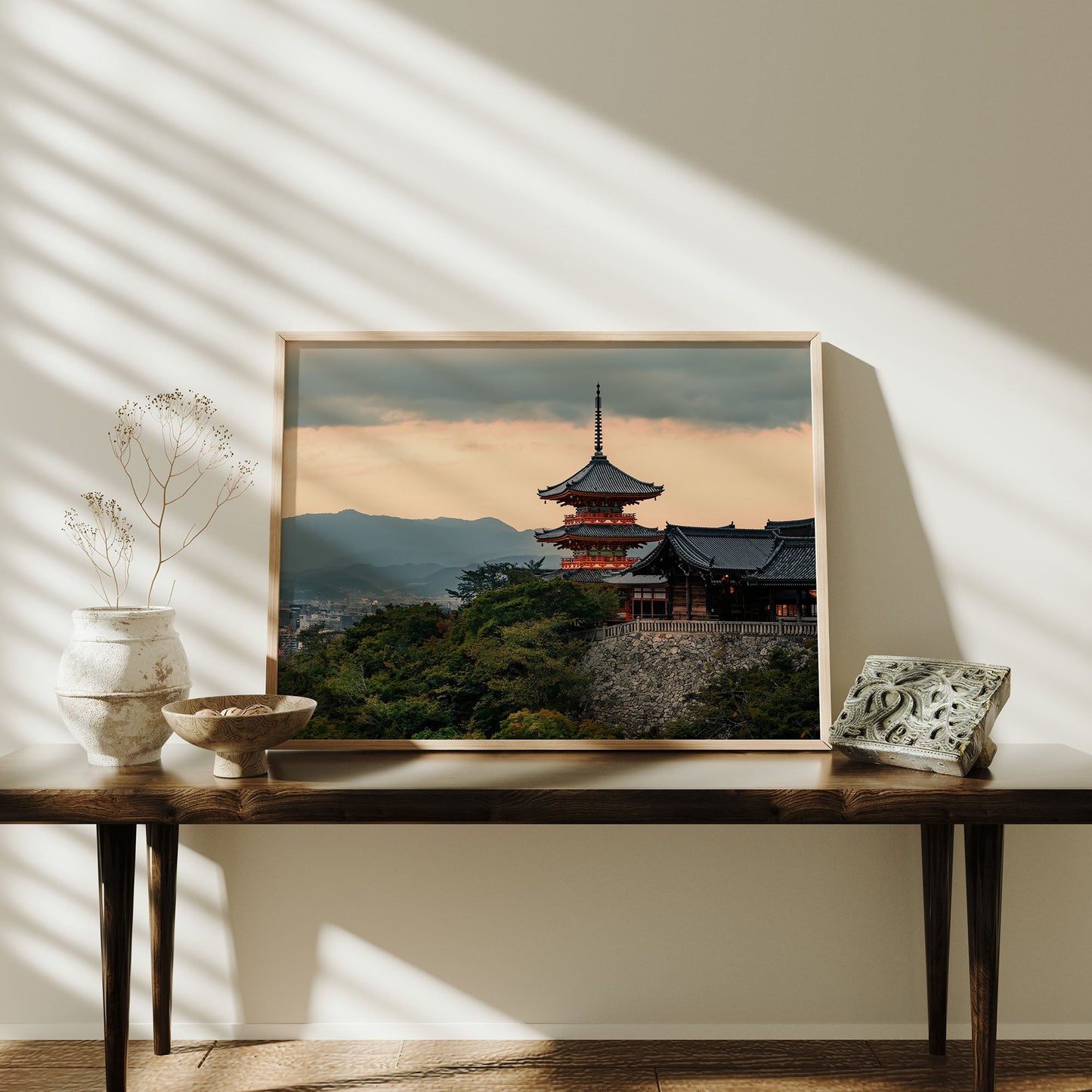 Kiyomizu-dera Sunset II framed photo on a wooden table with vases, decor, and sunlight streaming through blinds.