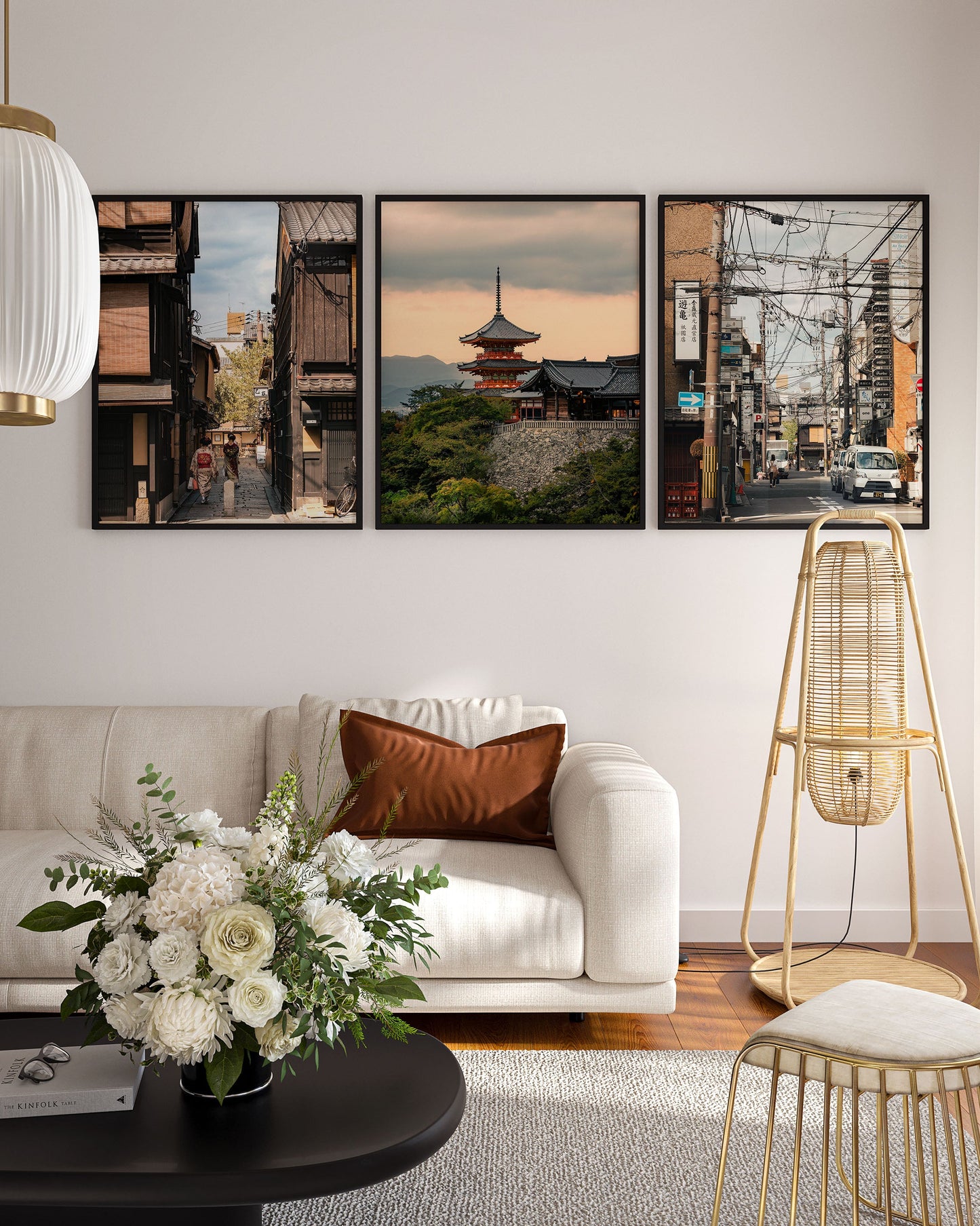 A modern living room with a white sofa, flower arrangement, and Kyoto Allure - Set of 3 cityscape photos on the wall.