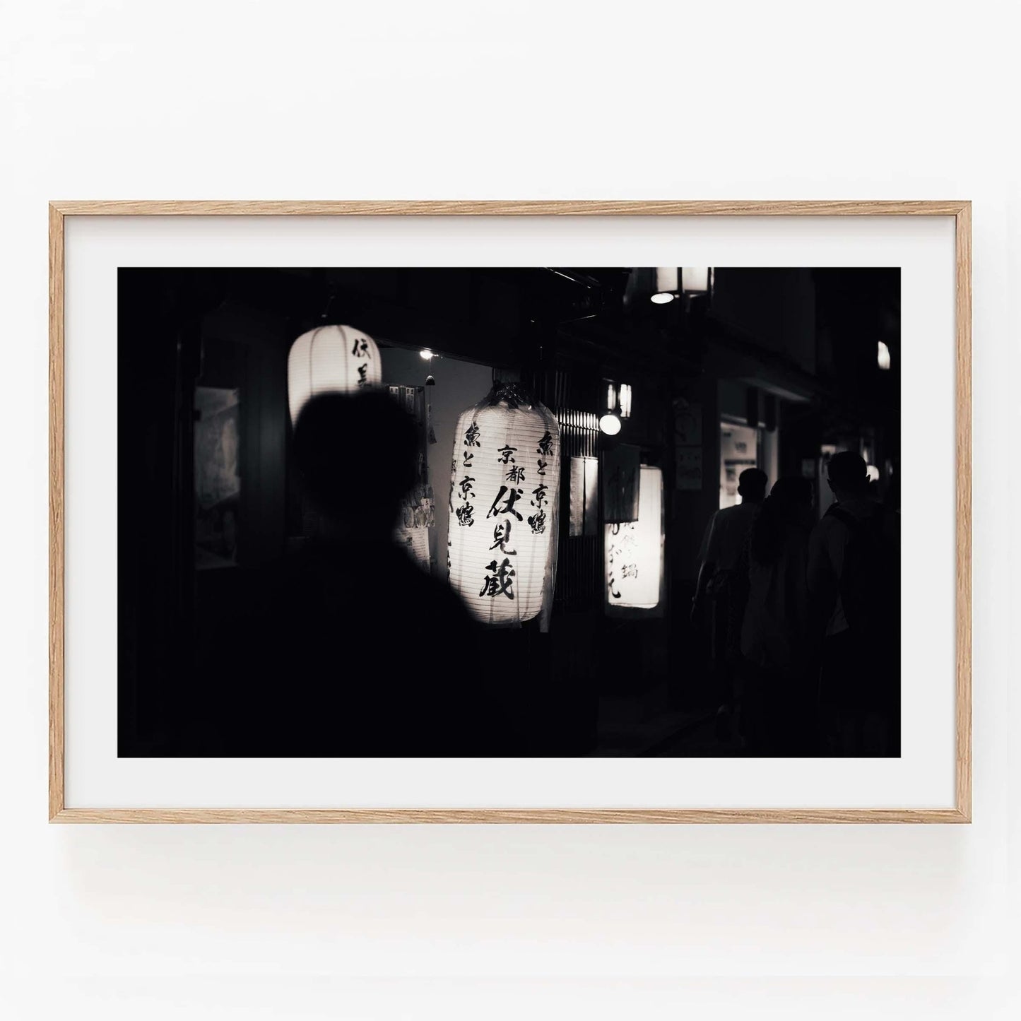 Kyoto At Night Black and White: Japanese lanterns glow with silhouetted figures in the foreground.