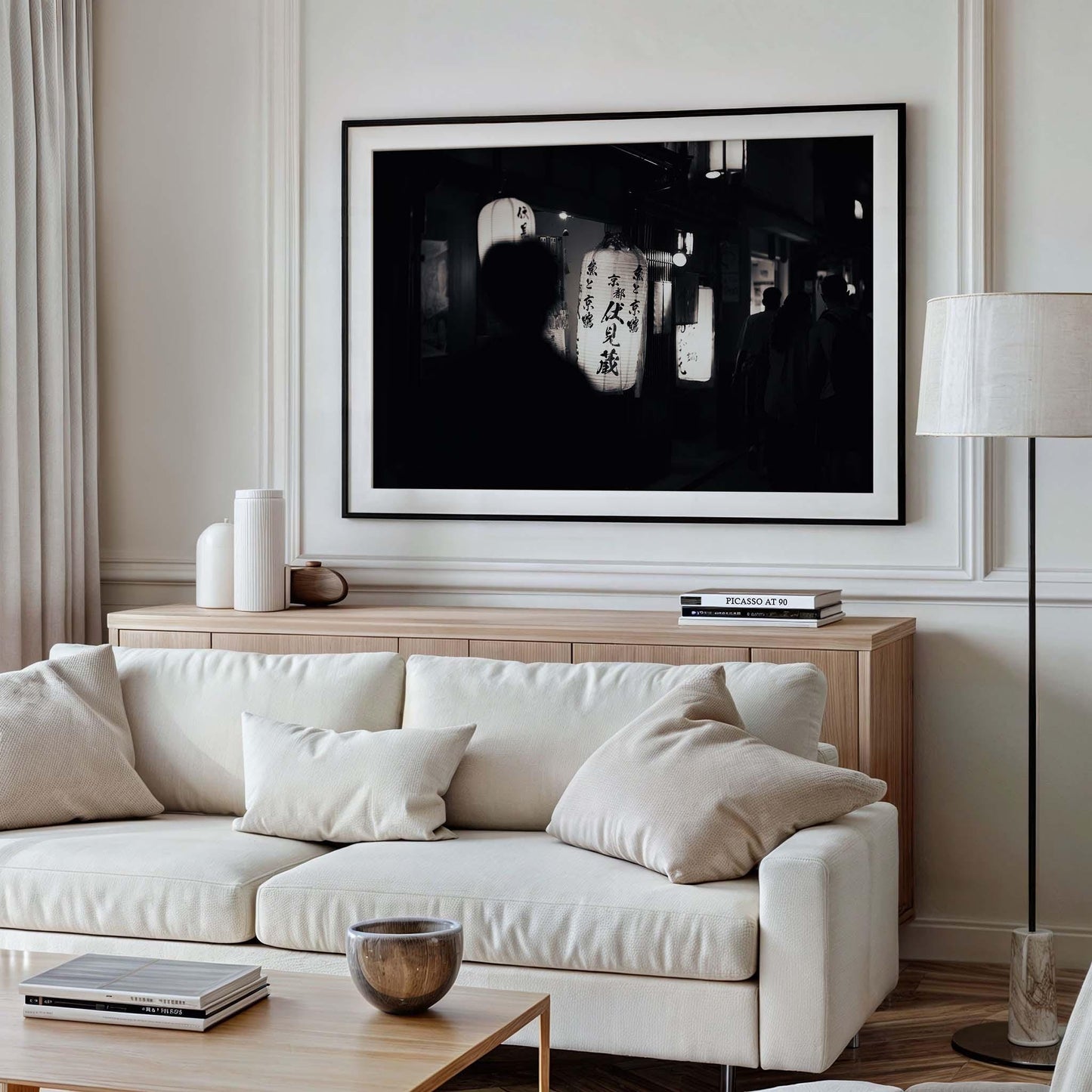 A modern living room with a white sofa, beige pillows, wood table, and Kyoto At Night Black and White wall art.