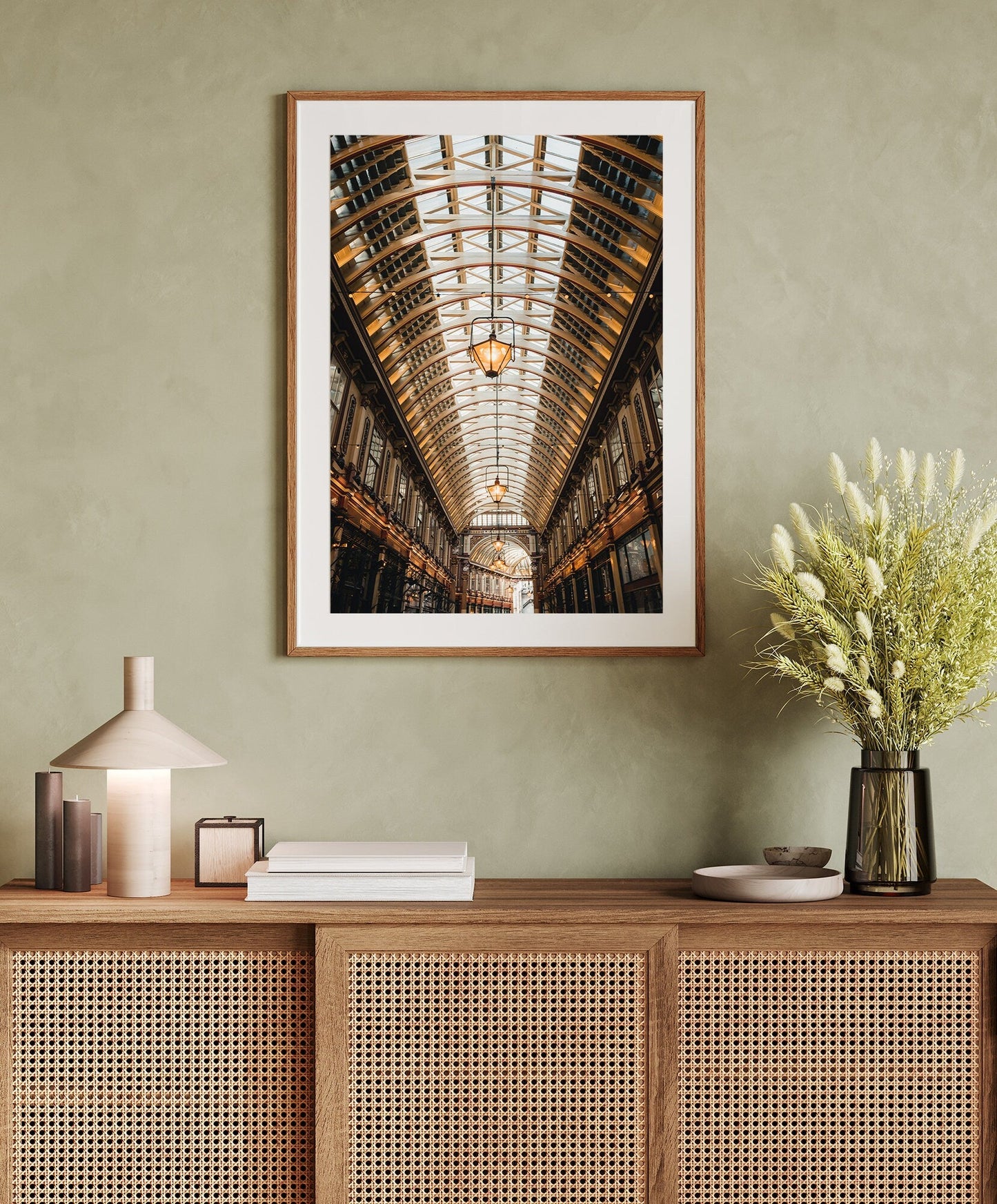 Leadenhall Ceiling print on a neutral wall above a rattan cabinet with decor and floral vase.