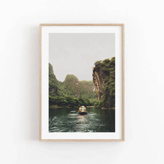 Framed Limestone Waterway: photo of a boat on a tranquil river amid lush cliffs under a cloudy sky.