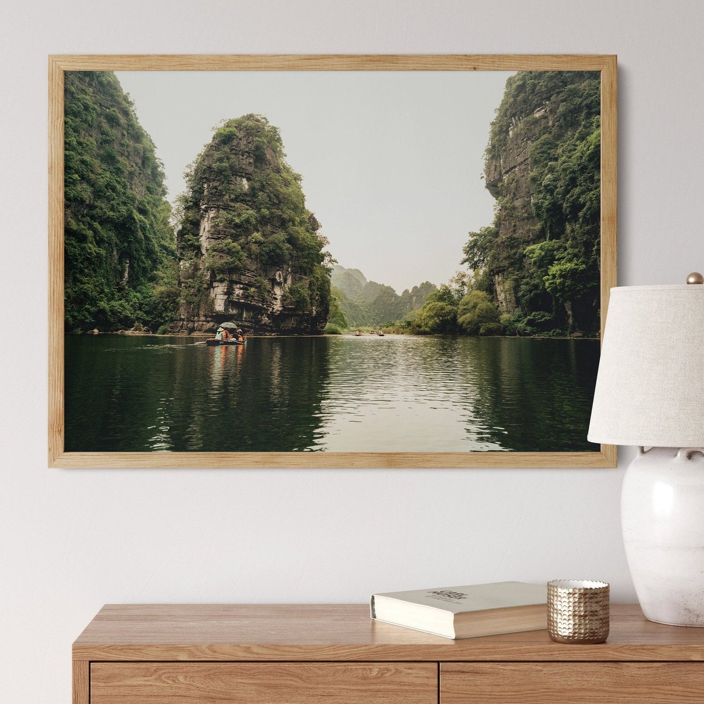 Limestone Wonders landscape photo above a wooden dresser depicts a serene lake with towering green cliffs.
