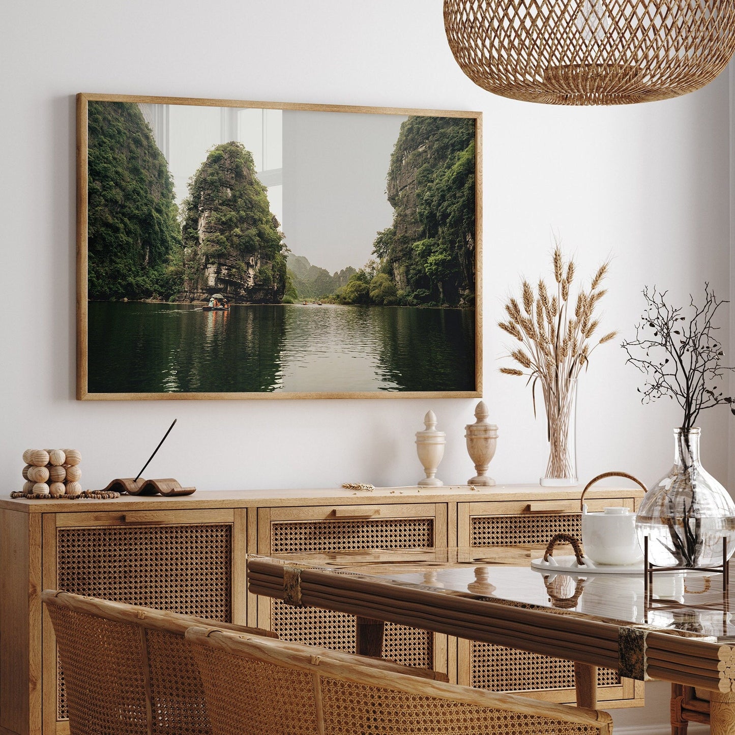 Dining room with wicker furniture and a Limestone Wonders landscape painting of a tranquil river scene on the wall.