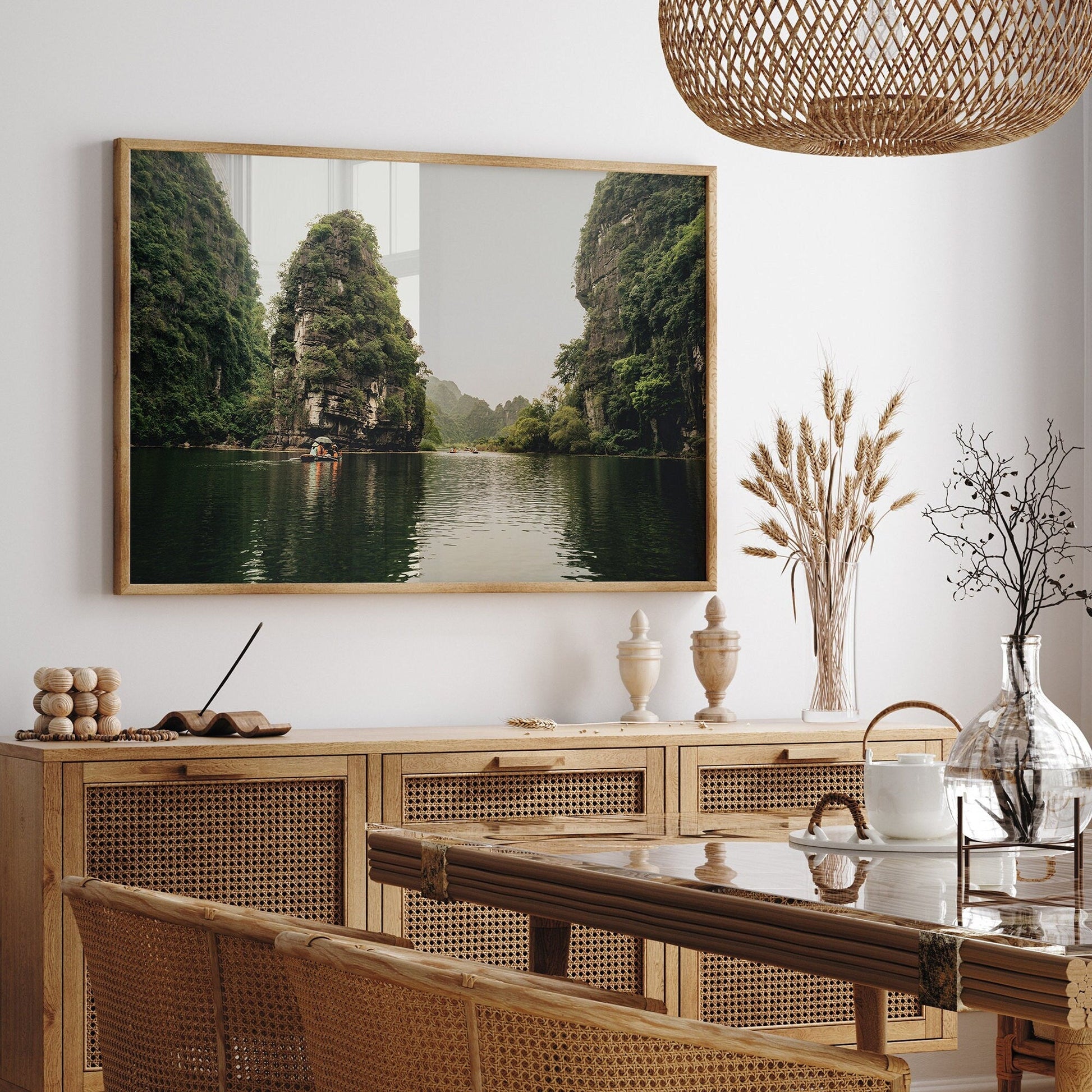Dining room with wicker furniture and a Limestone Wonders landscape painting of a tranquil river scene on the wall.