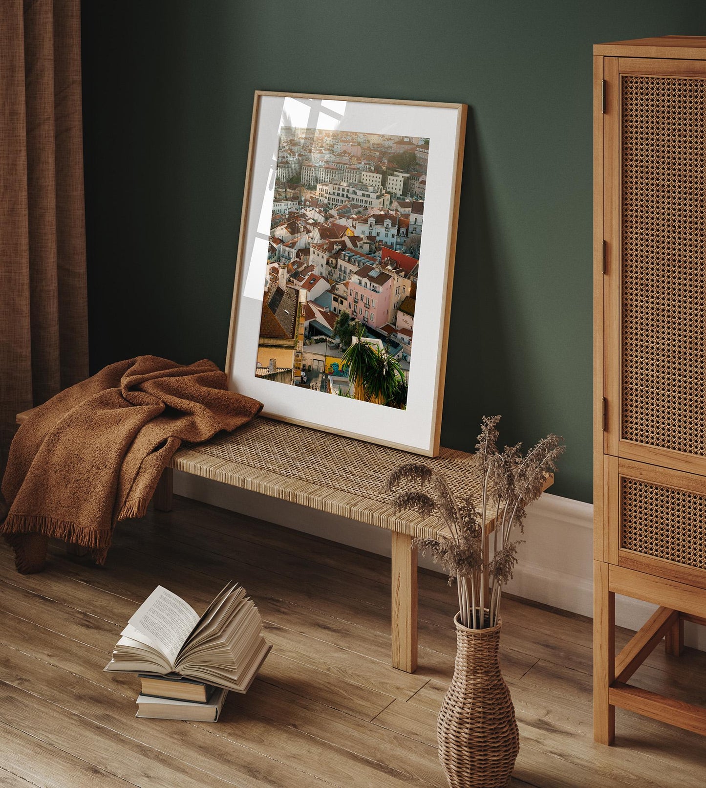 Lisbon Layers framed cityscape on woven bench with brown blanket, book, and dried flowers on wood floor.