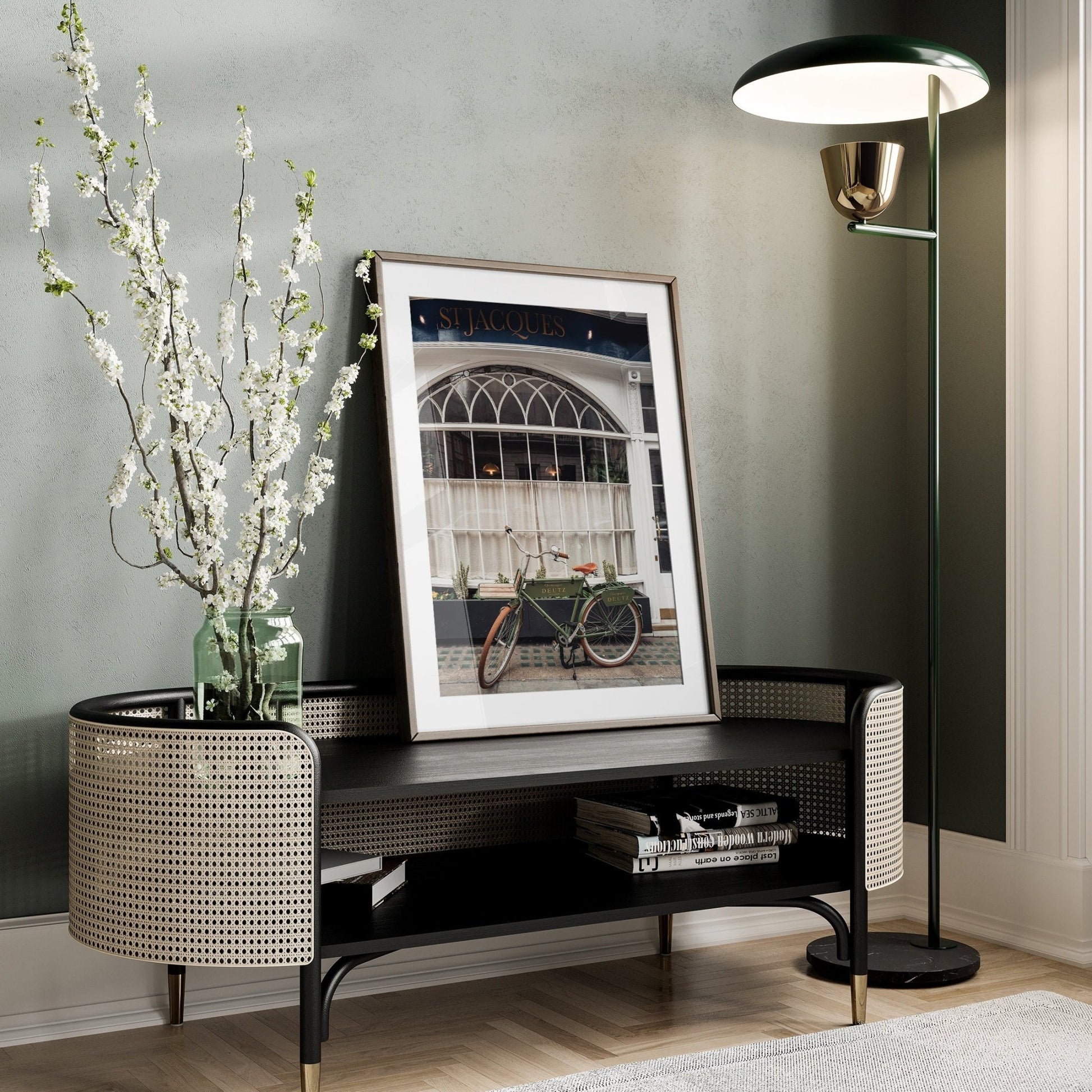 Stylish living room corner with a woven bench, tall lamp, blossoms in a vase, and the London Bike framed photo.