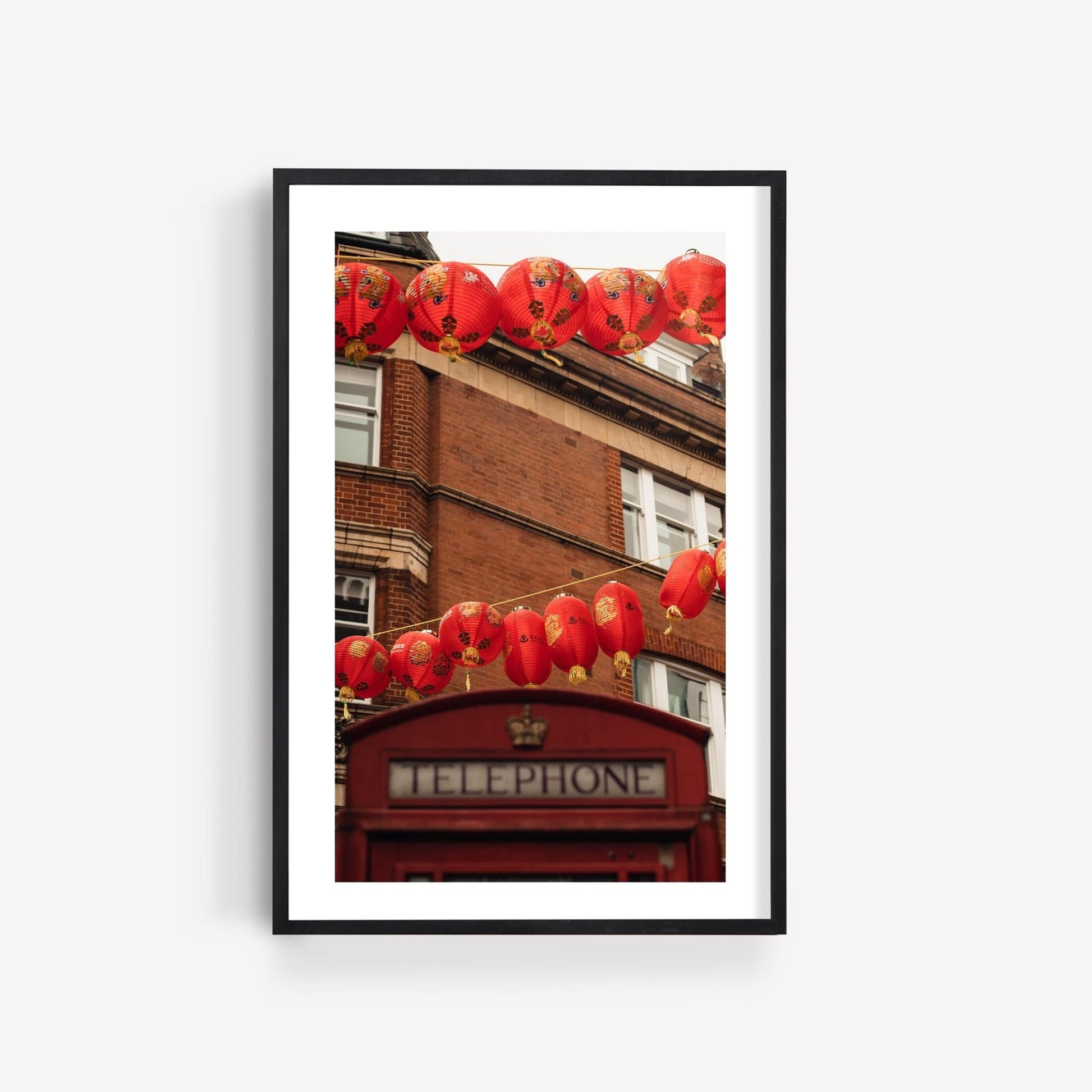 Framed photo titled London Chinatown featuring a red telephone booth and lanterns by a brick building.