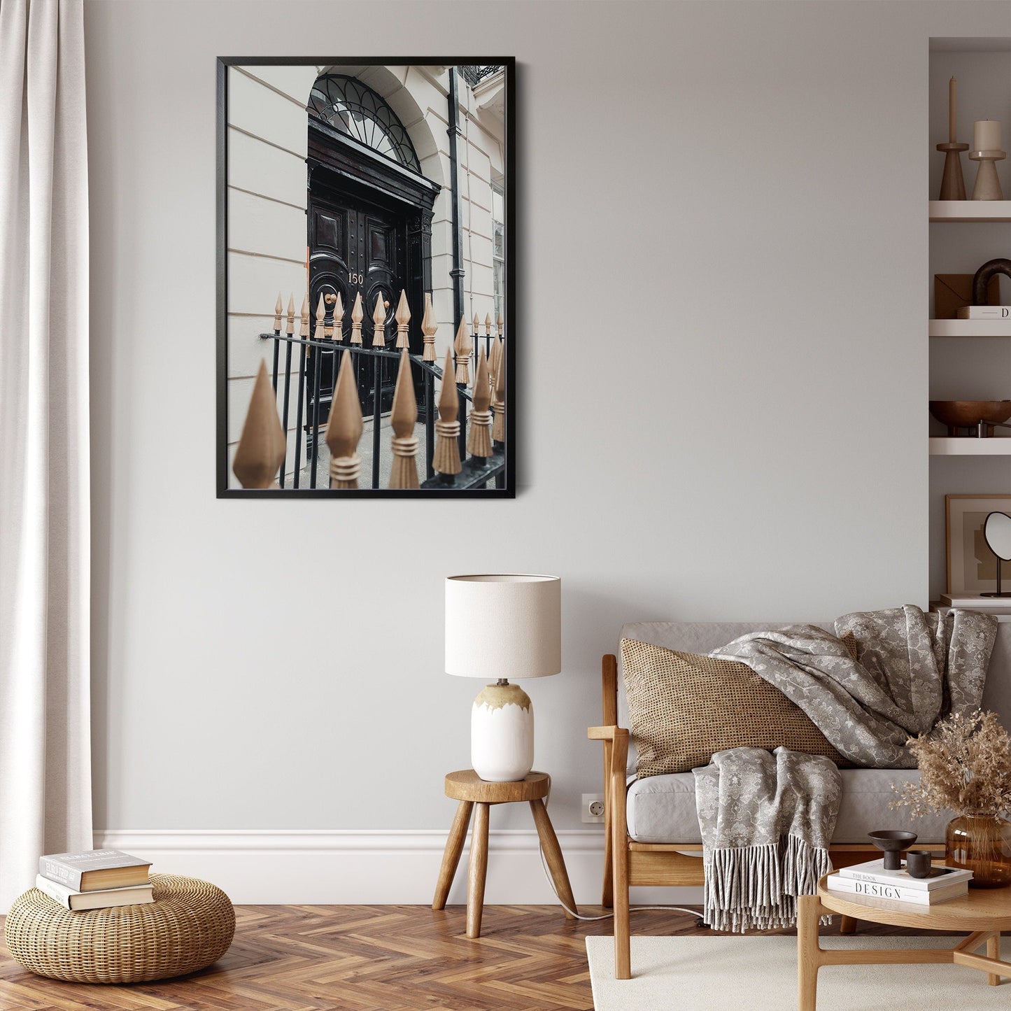 A cozy living room with a London Door painting, a lamp, and a wooden stool near a beige sofa.