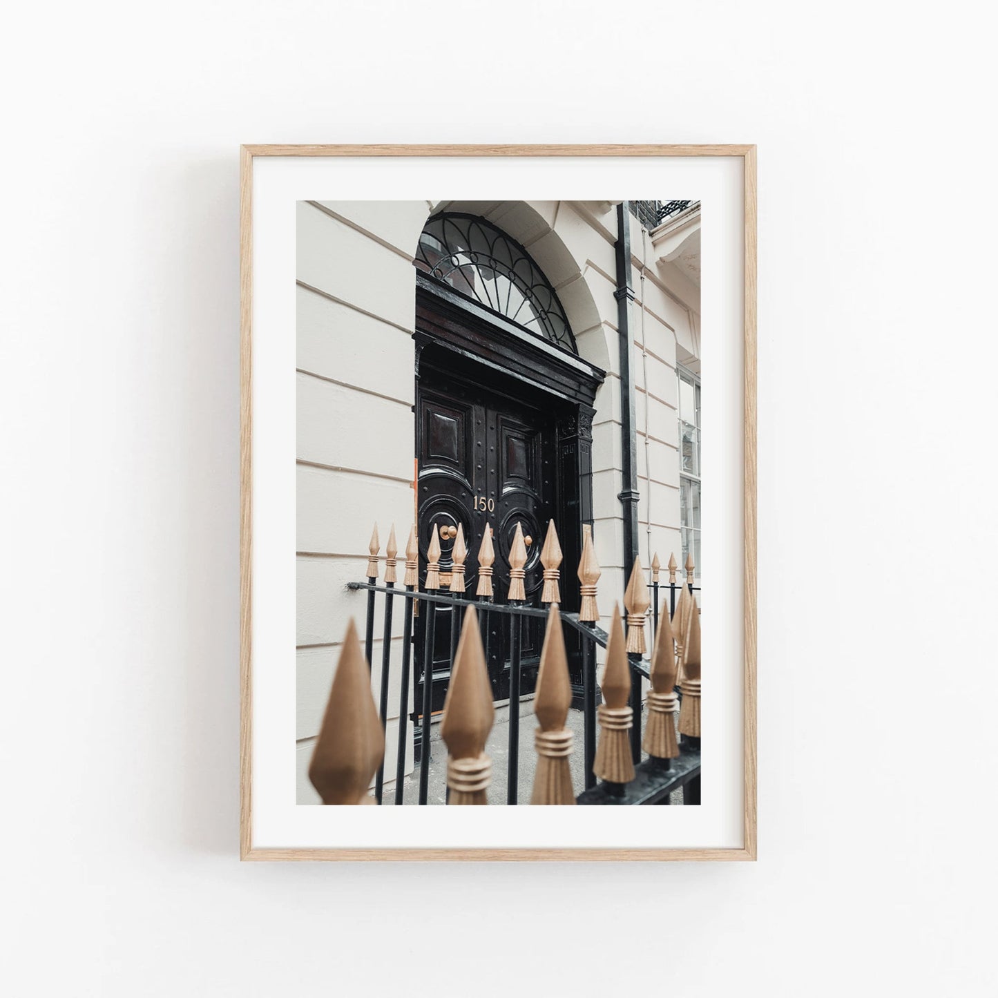 Framed photo titled London Door showing a classic arched doorway with a decorative iron fence and gold spikes.
