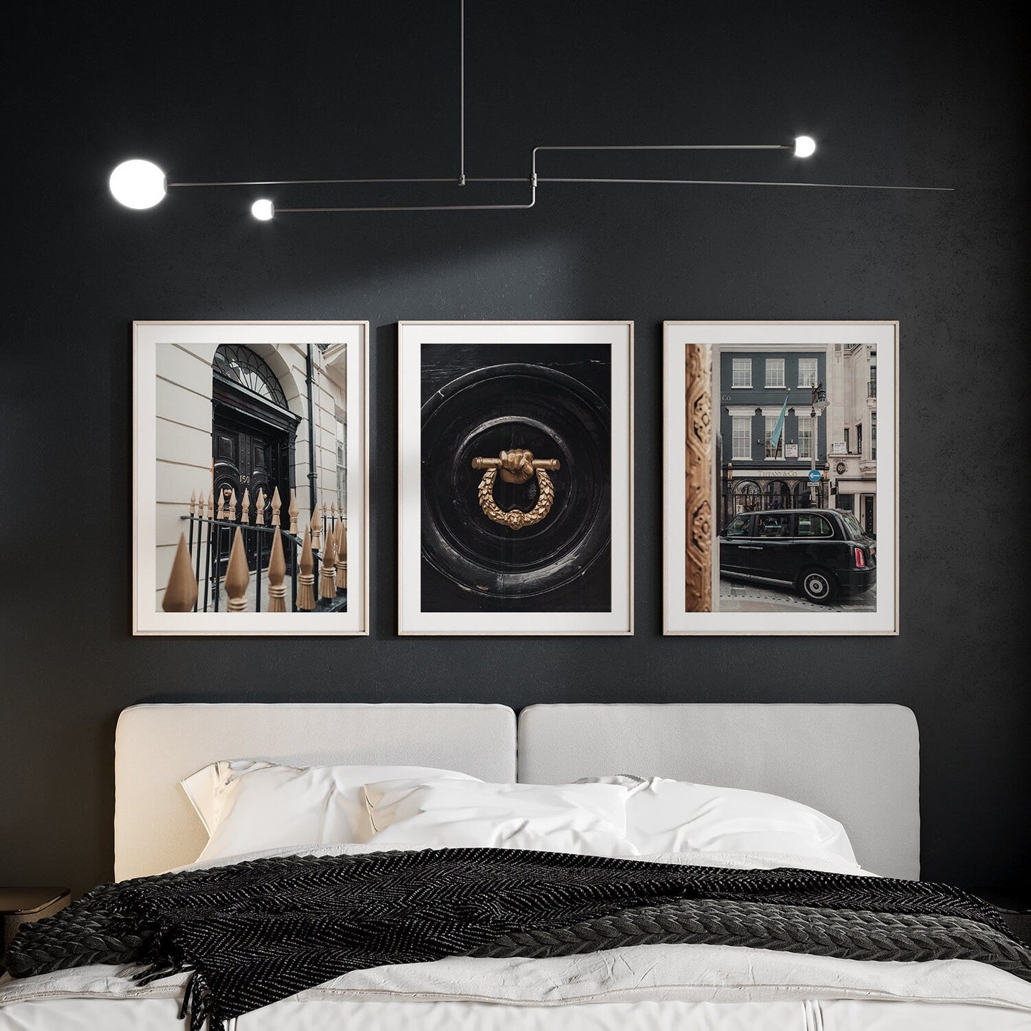 Bedroom with dark walls features a modern bed and the London Flair - Set of 3 art pieces above the headboard.