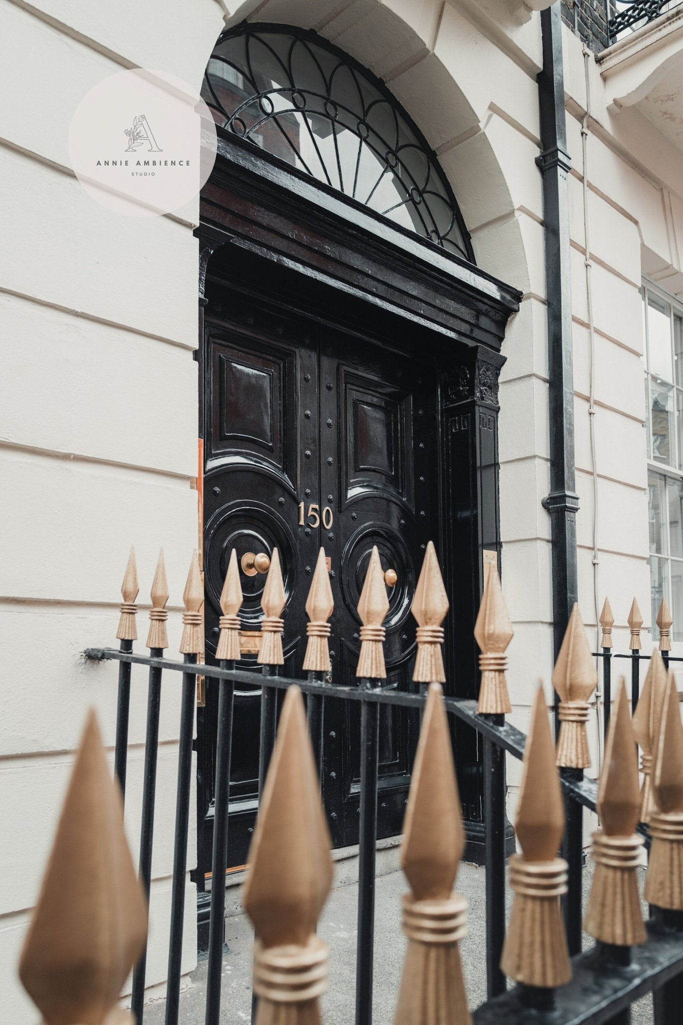 Elegant black door with number 150, framed by ornate architecture and a gold-tipped black fence. London Flair Set of 3.