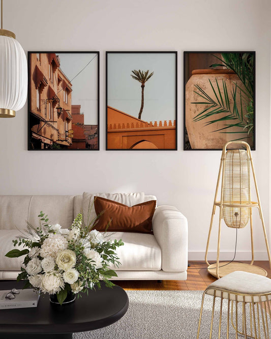 Living room with a beige sofa, floral arrangement, and Marrakesh - Set of 3 framed photos of architecture and plants.