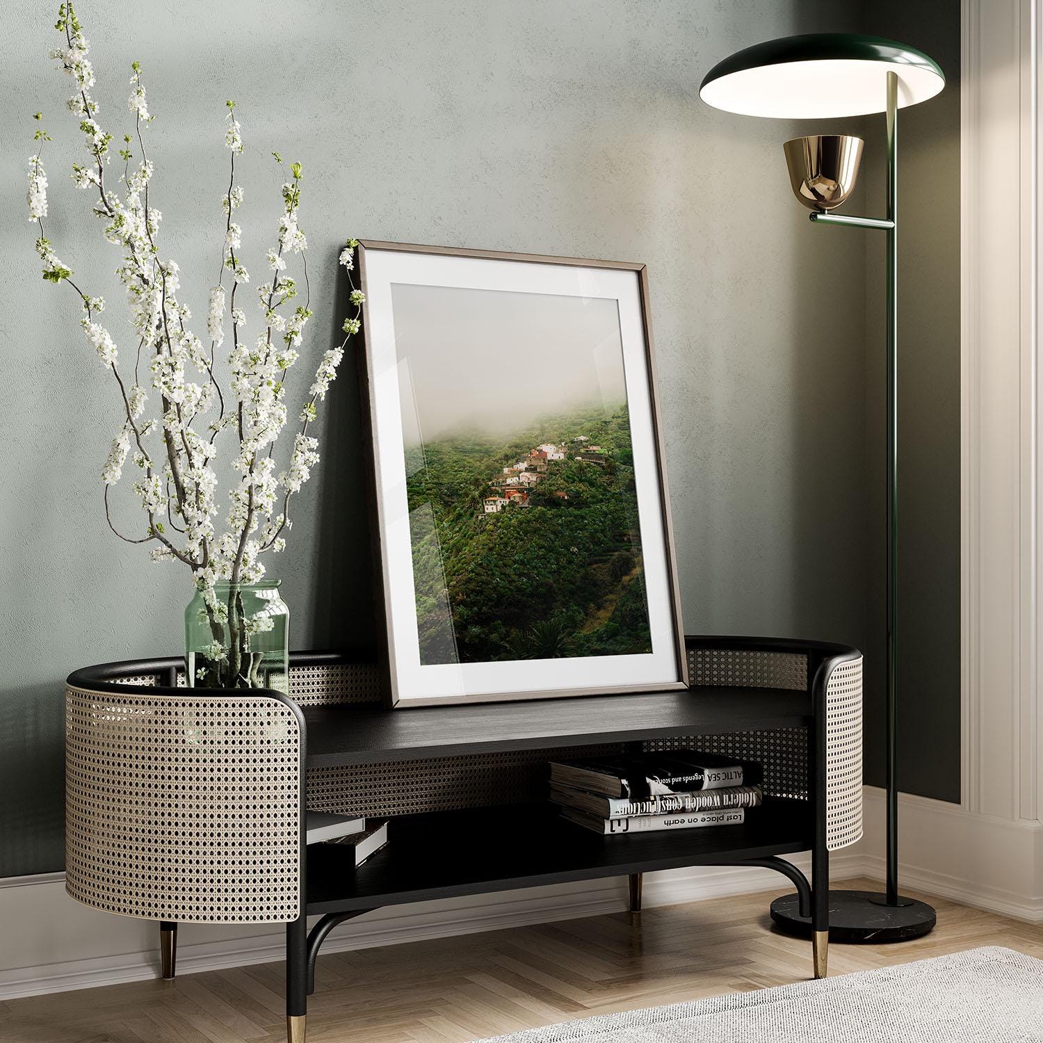 Masca Mist framed photo on a bench, with a tall vase of branches and floor lamp in a modern living space.