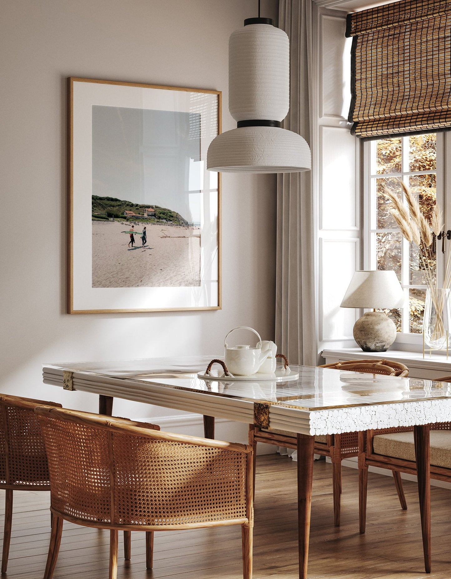 A cozy dining room with a wooden table, wicker chairs, pendant light, and Milady Surfers photo on the wall by a bright window.