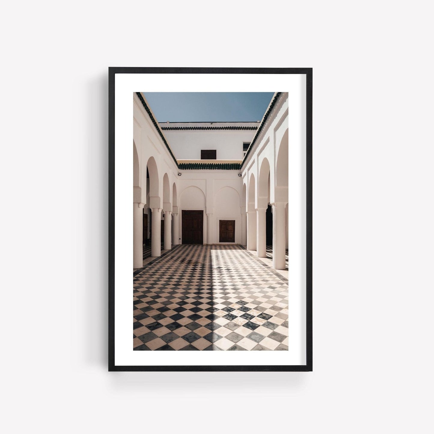 Framed Moroccan Architecture I photo of a courtyard with arches and checkered tile floor against a white wall.