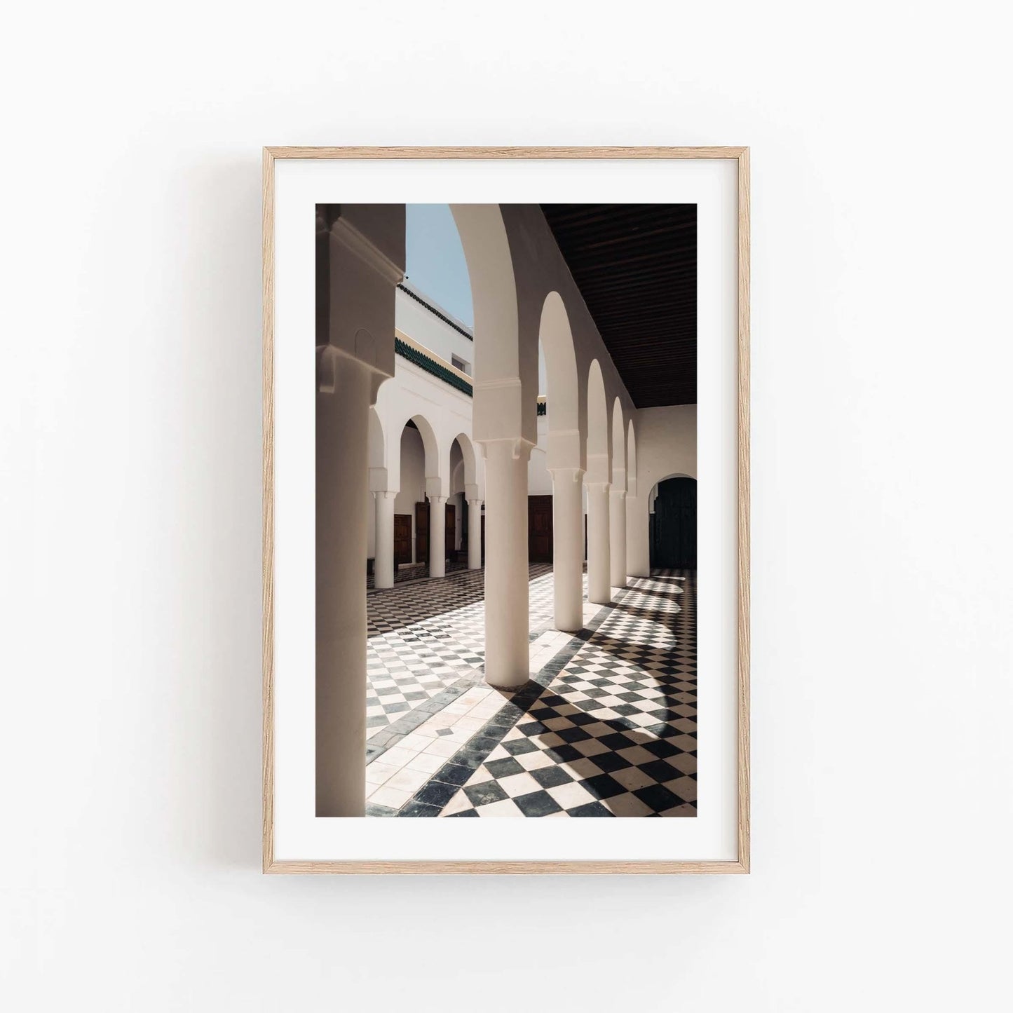 Framed photo titled Moroccan Architecture II, featuring a sunlit corridor with arches and checkered floor.