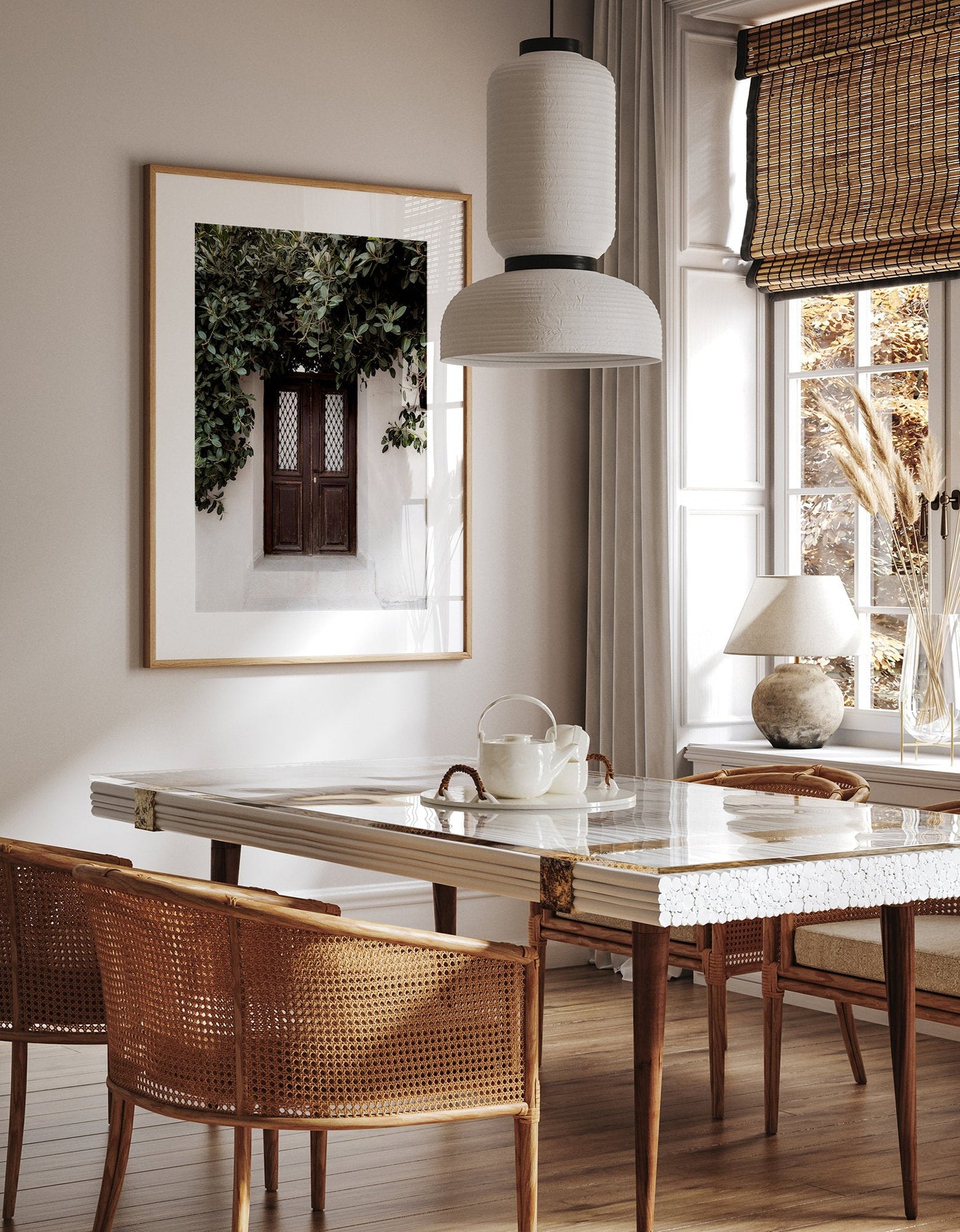 Cozy dining spot with marble table, wicker chairs, teapot, pendant lamp, and Nature’s Door wall art by sunlit window.