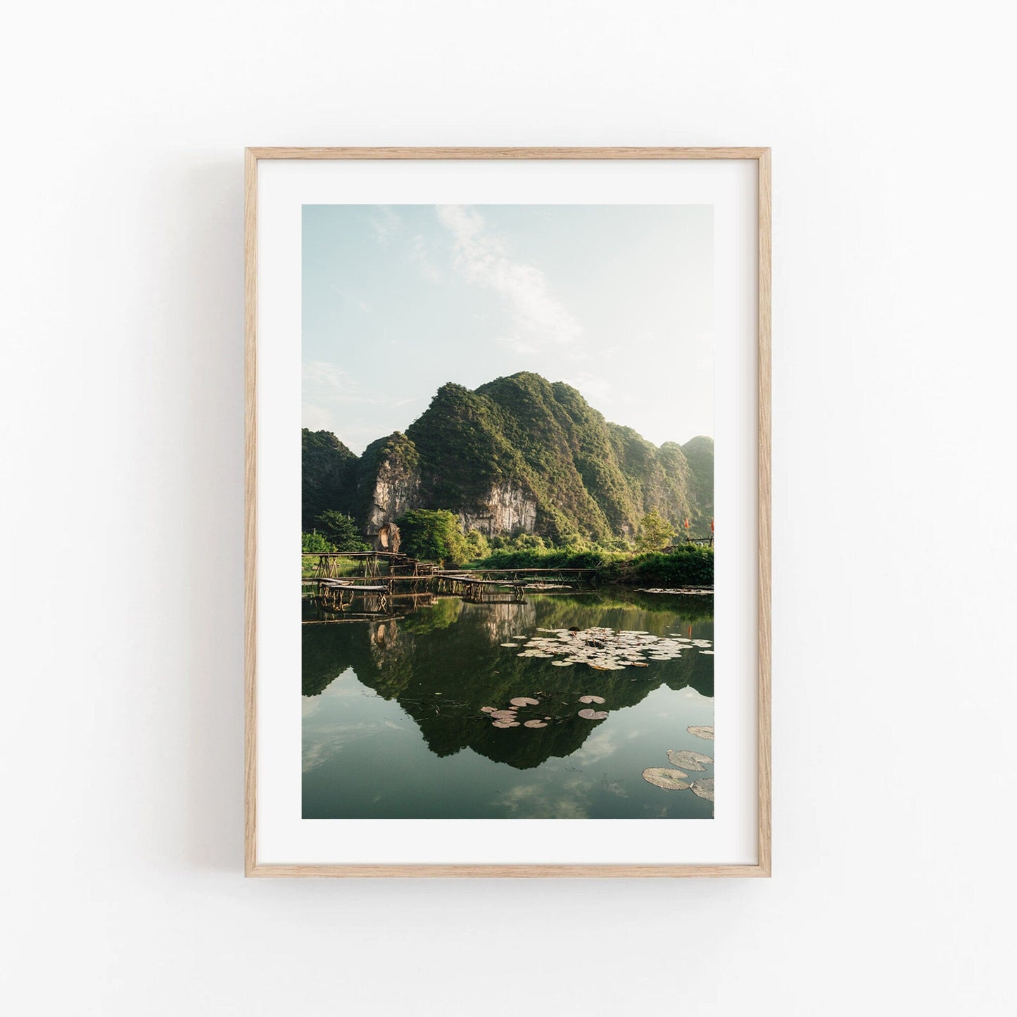 Framed Natures Symmetry photo: green mountains, reflective lake with lily pads.