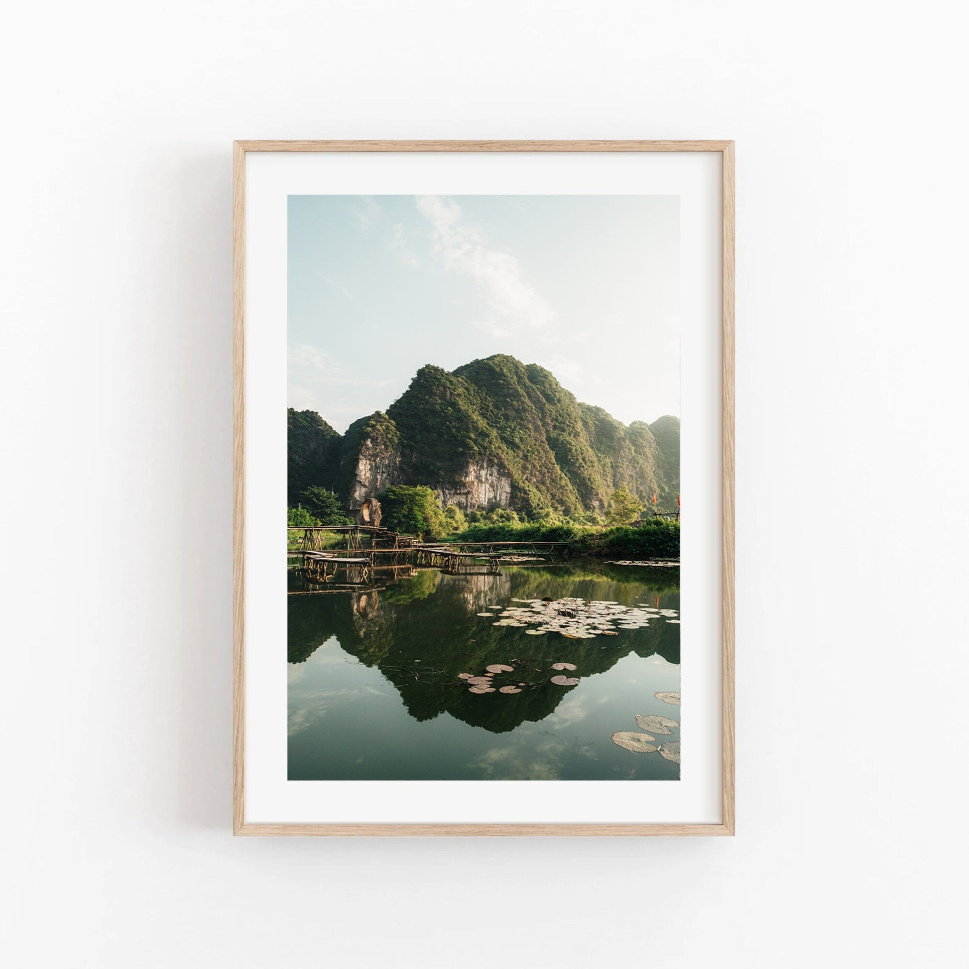 Framed Natures Symmetry photo: green mountains, reflective lake with lily pads.