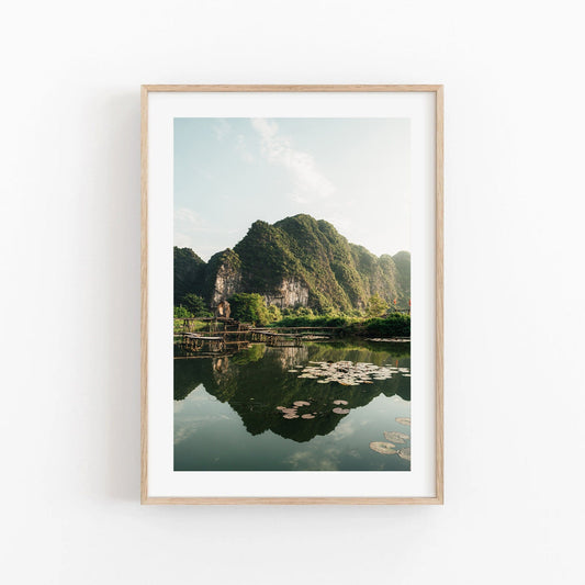 Framed Natures Symmetry photo: green mountains, reflective lake with lily pads.