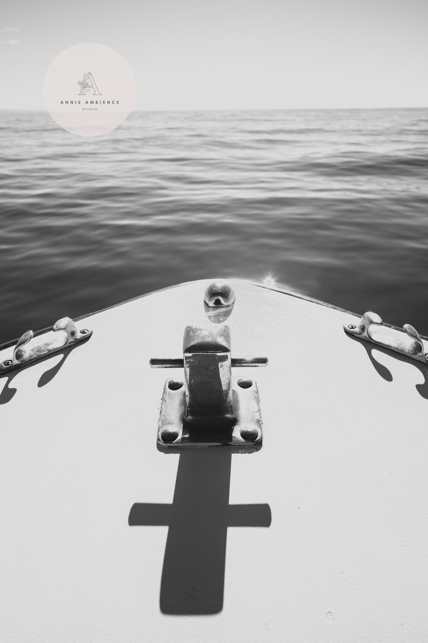 Nautical Elegance Black and White - Set of 3: A boat’s bow faces calm seas, its shadow crossed across a sunlit deck.