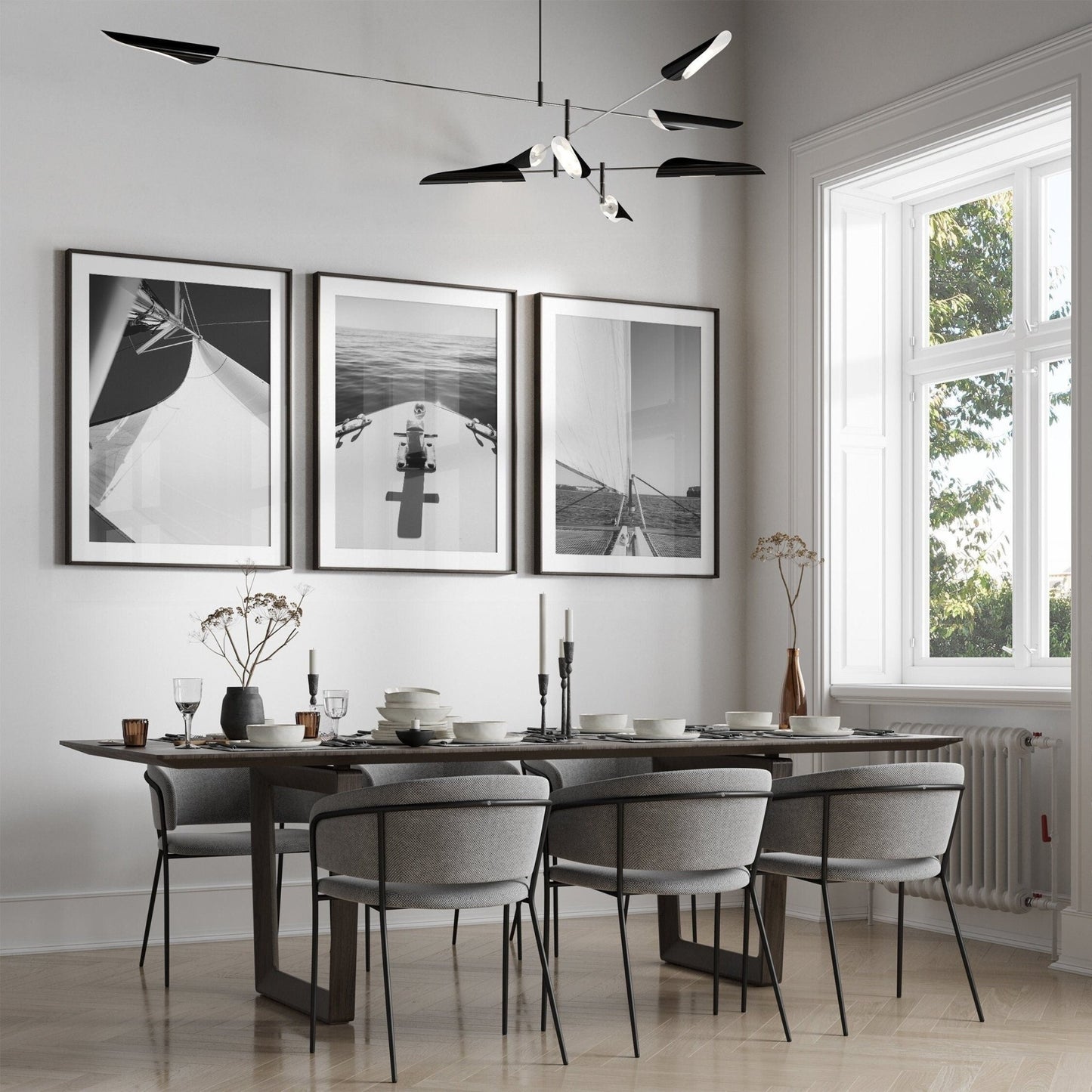 Modern dining room with a dark table, six chairs, and Nautical Elegance Black and White - Set of 3 wall art.