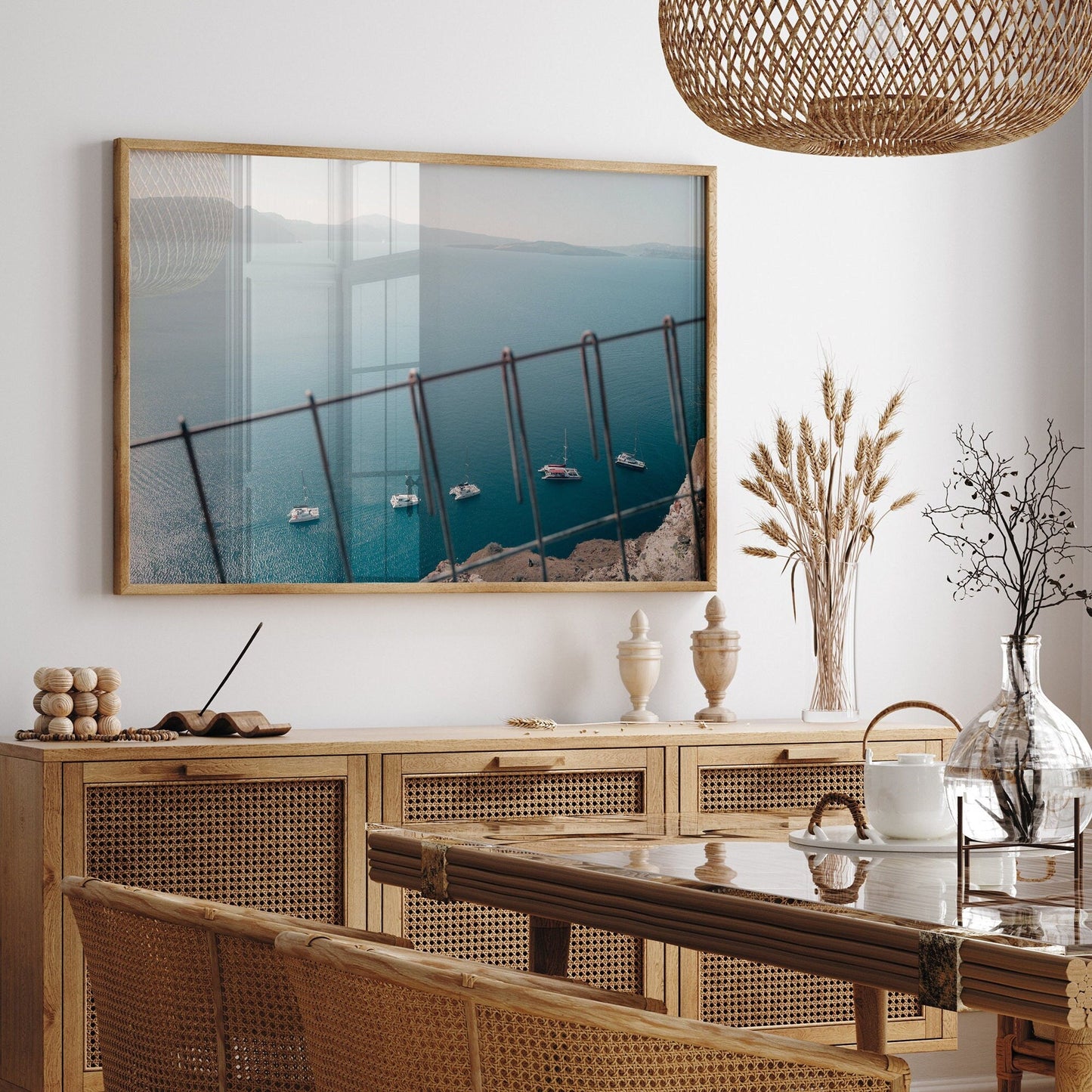 Dining room with Nautical Formation sideboard, rattan chairs, coastal photo, dried plants, and pottery on display.