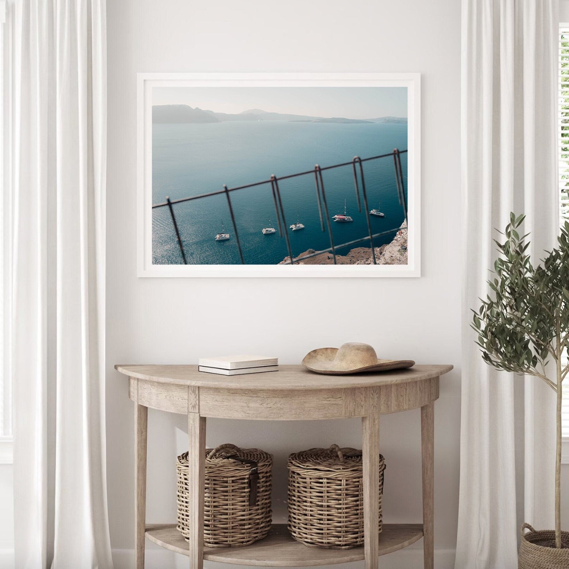 Nautical Formation hangs in a white room above a wooden table with woven baskets and a potted plant.