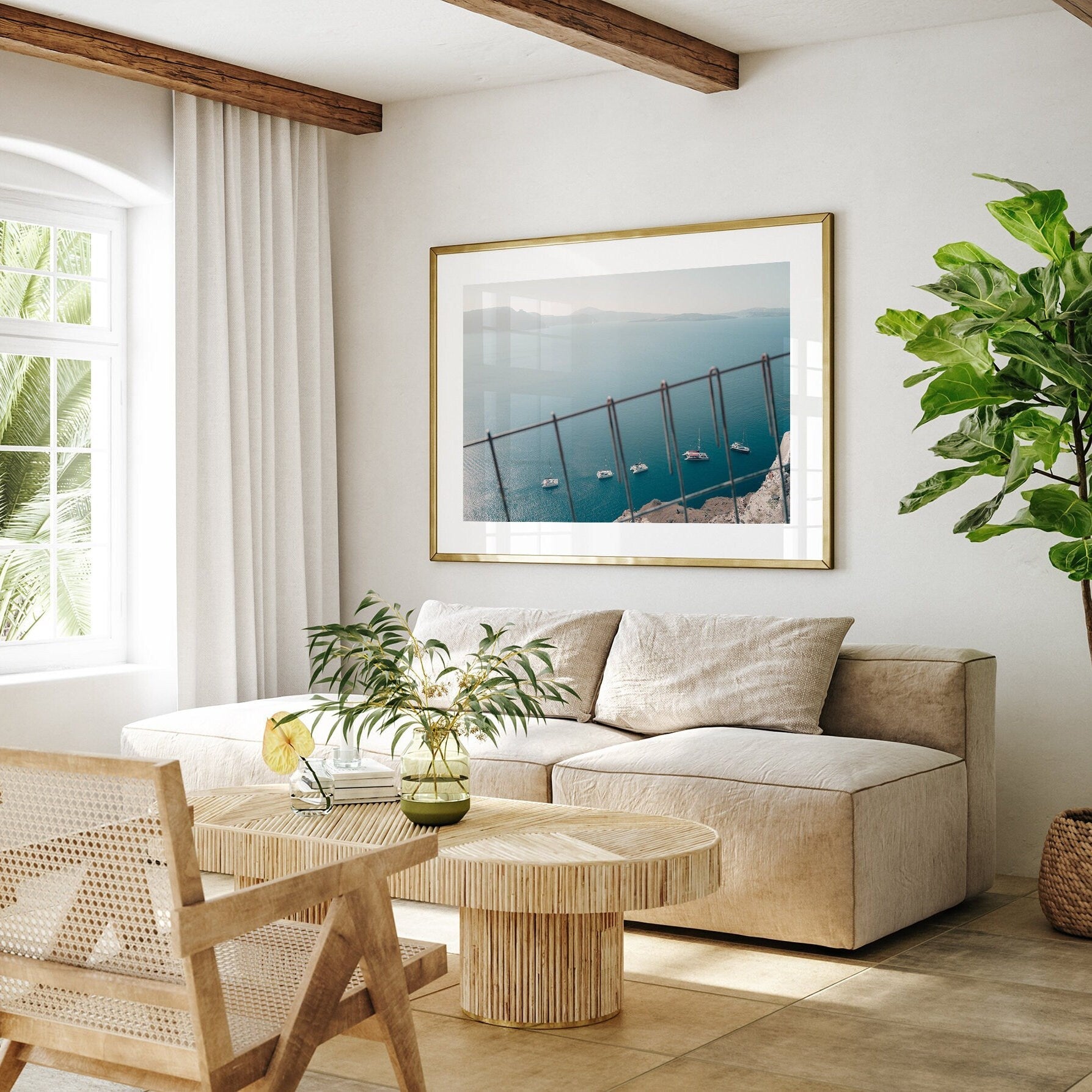 Cozy living room featuring a beige sofa, wooden table, Nautical Formation framed photo, and a plant by a large window.