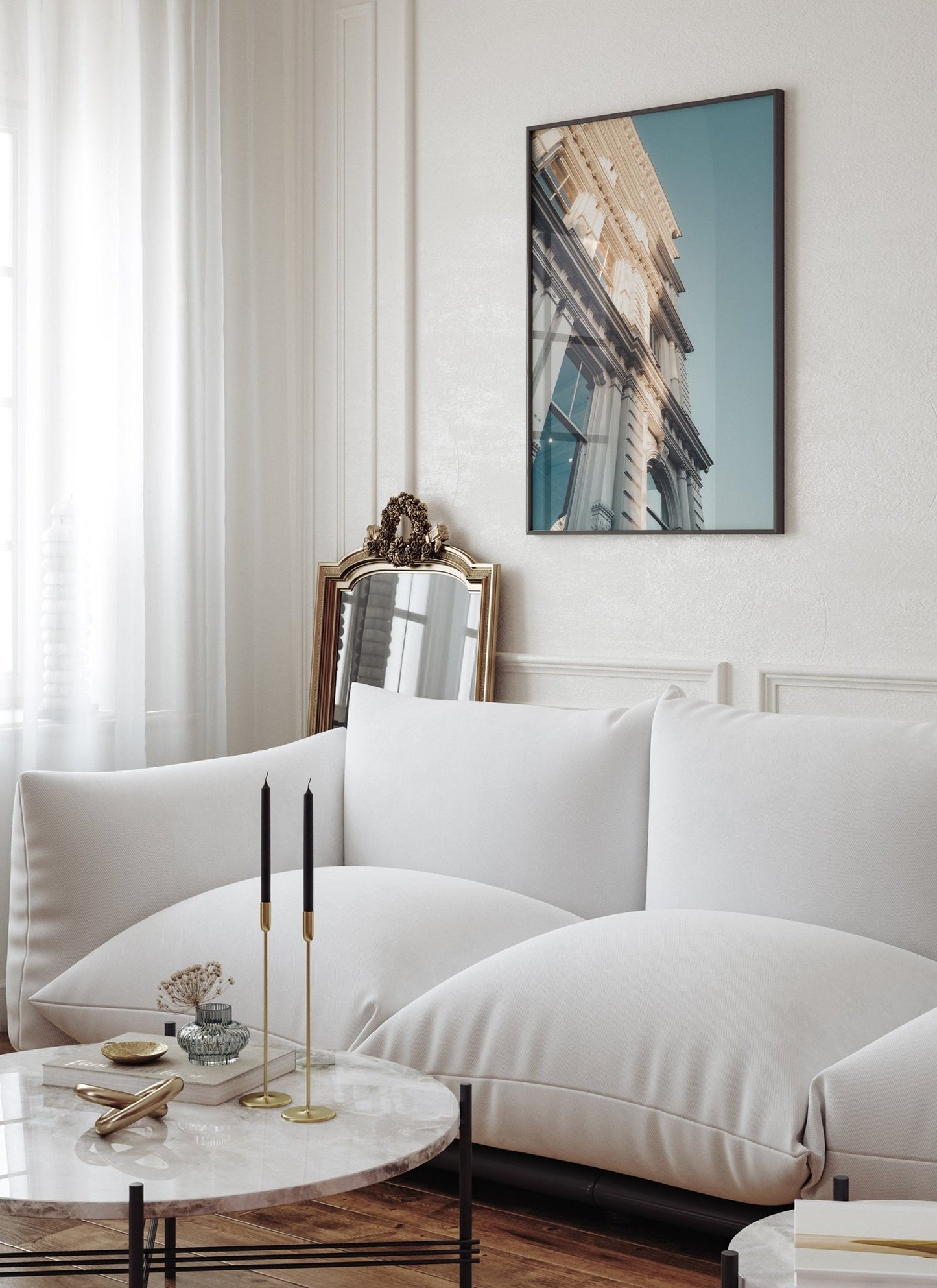 Modern living room with a Noho I sofa, round coffee table, candles, and a photo of a building on the wall.