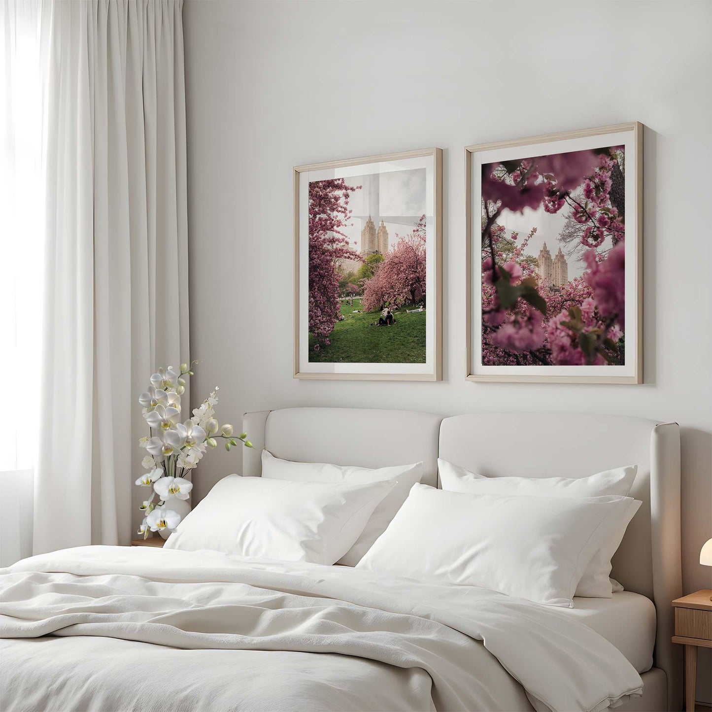 A cozy bed with white bedding, floral decor, and two NYC Cherry Blossoms prints above the headboard.