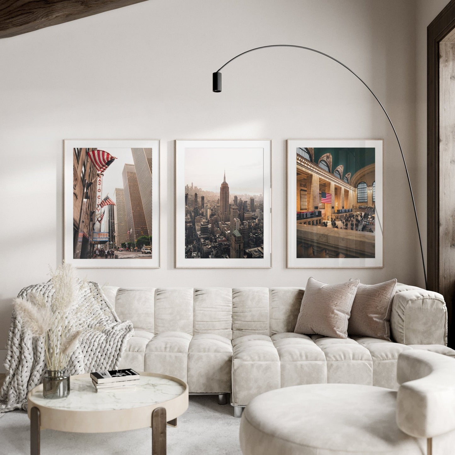 Cozy living room with a beige sectional, round table, and NYC Midtown - Set of 3 cityscape photos on the wall.