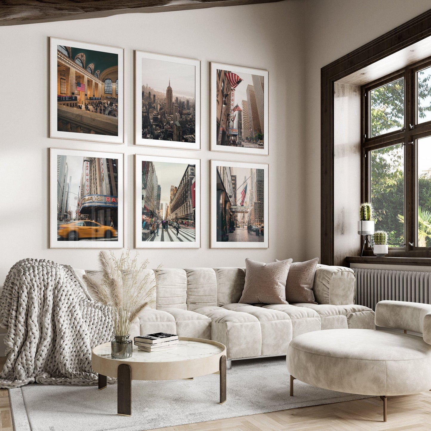 Cozy living room with a cream sectional sofa, round table, and NYC Midtown - Set of 6 photos on the wall.