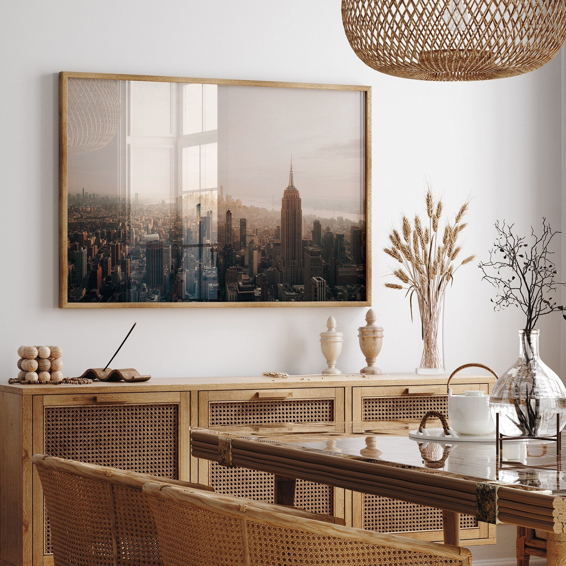 A chic dining room with NYC Skyline photo, a wooden table setting, and vases of dried flowers.