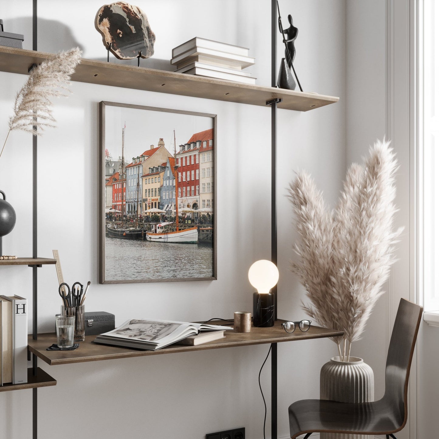 Minimalist workspace with floating shelves, Nyhavn Canal framed photo, pampas grass, and a small desk lamp.