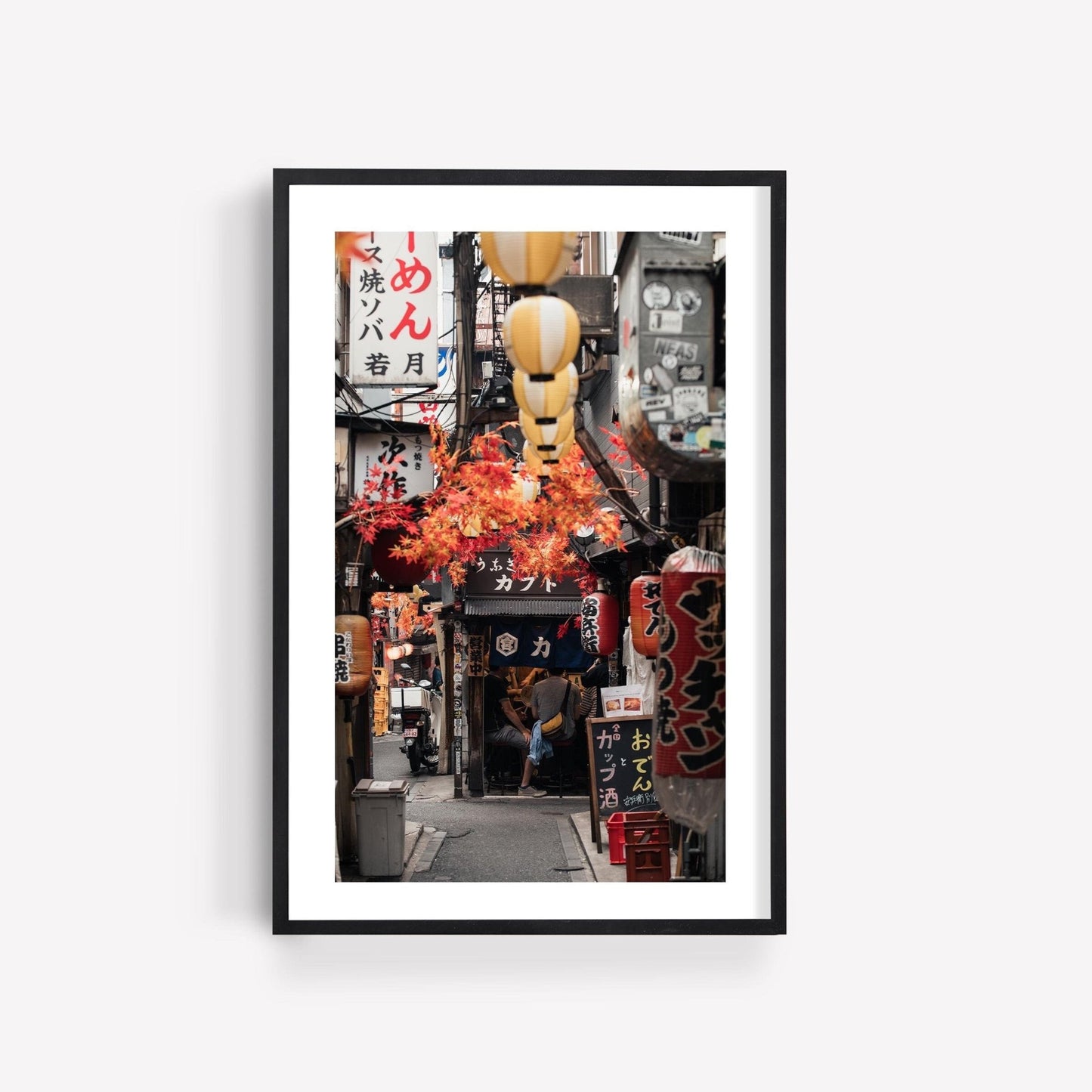 Framed photo titled Omoide Yokocho, showcasing a narrow Japanese alleyway adorned with lanterns and vibrant signs.