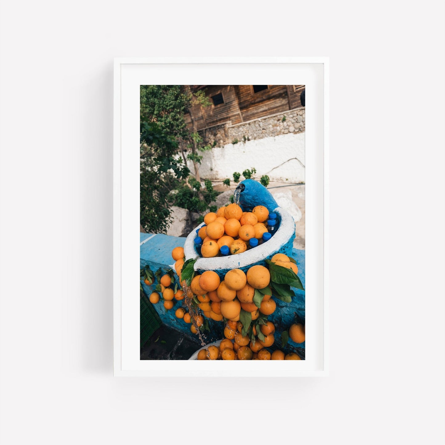A framed Orange Fountain photo shows oranges in a blue basket on a street with a rustic building backdrop.
