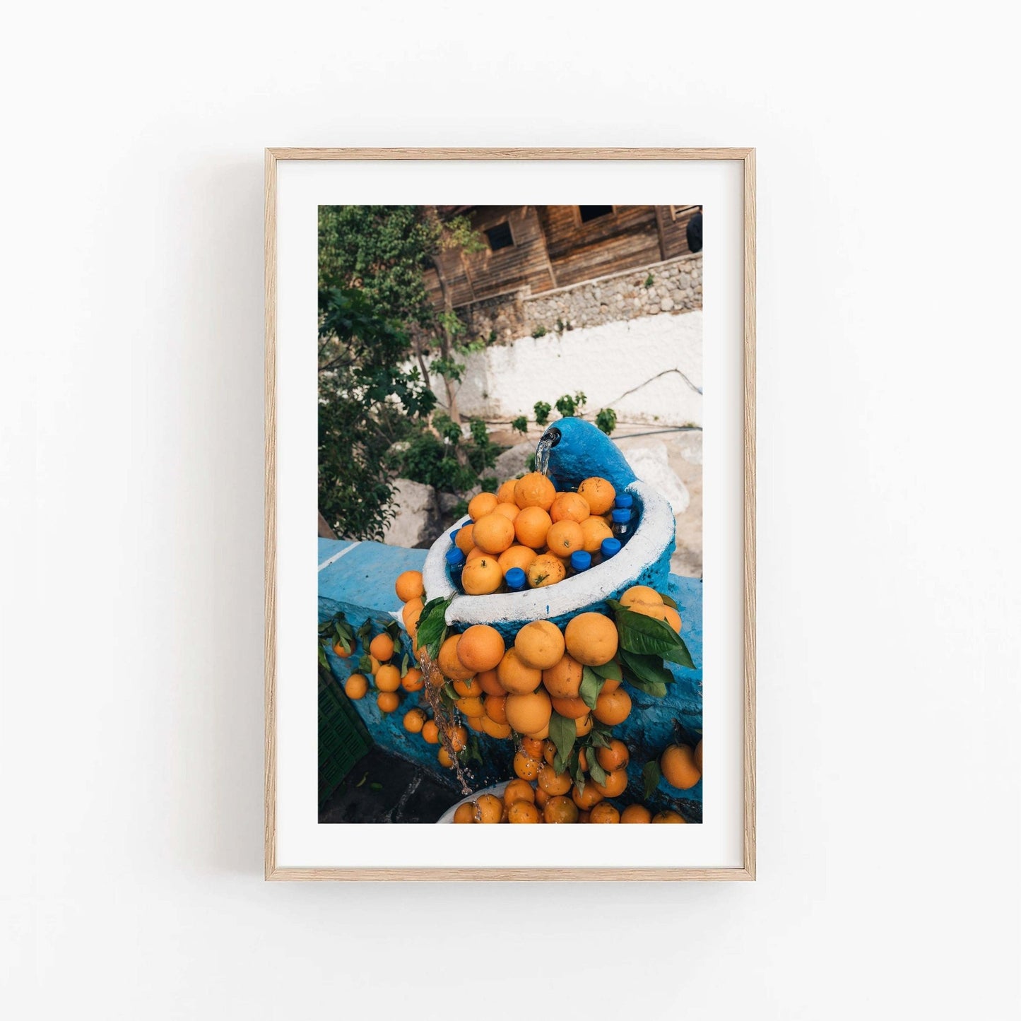 Photo of Orange Fountain in a wooden frame on a white wall.