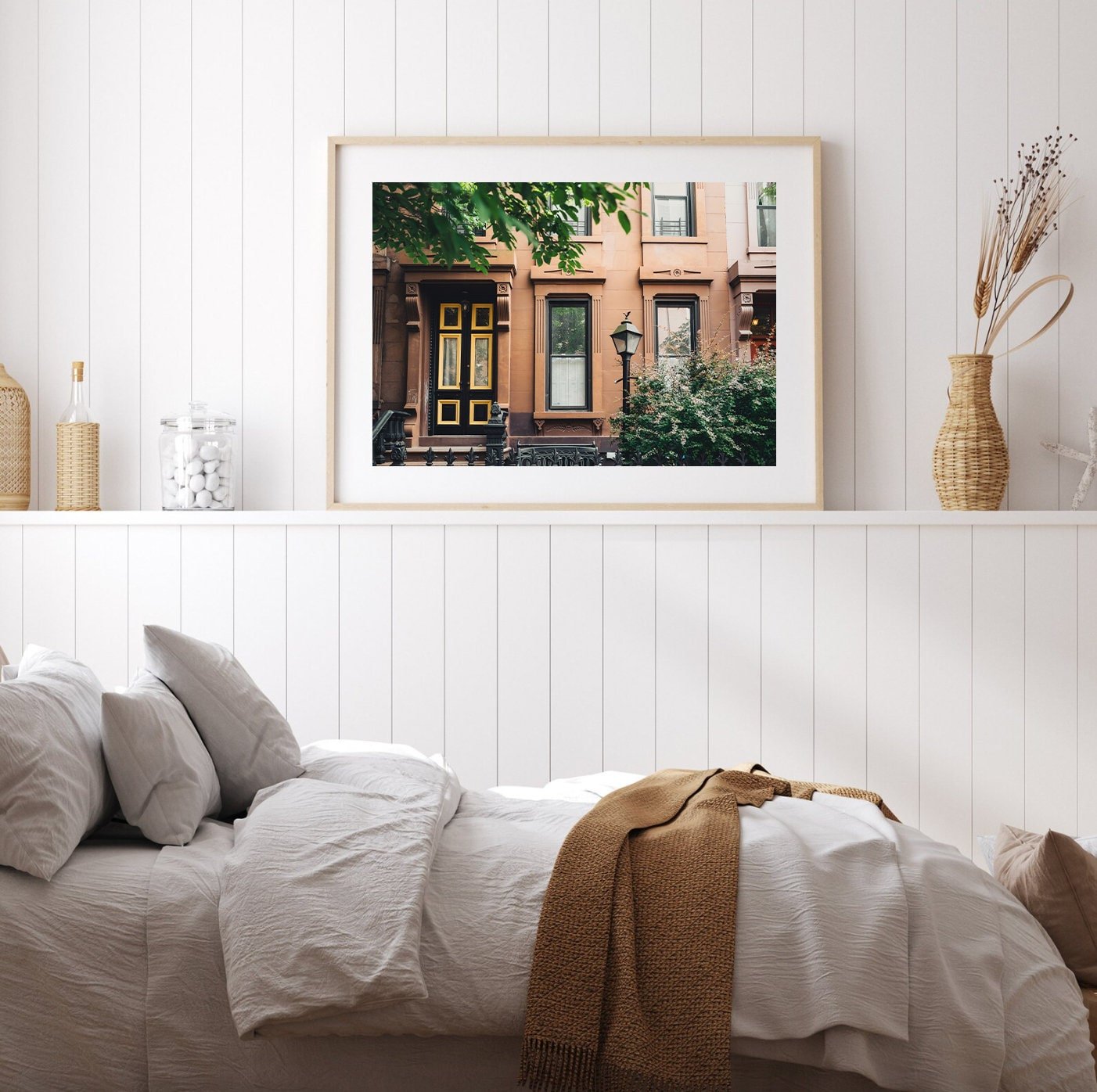 Cozy bedroom with Park Slope white shiplap walls, a bed, and a framed cityscape photo on the wall.