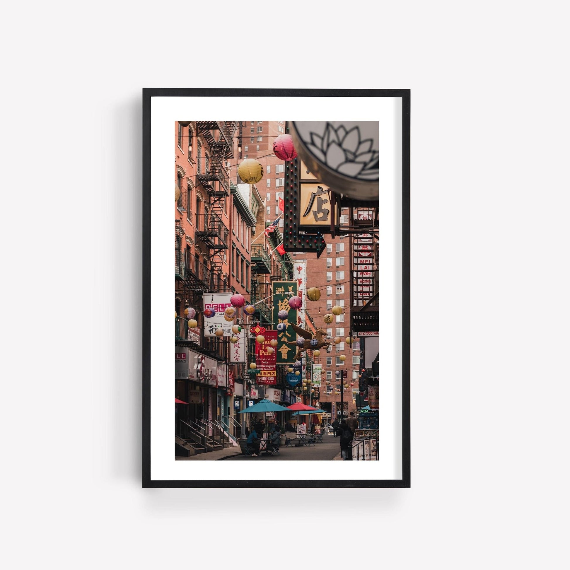 Framed photo named Pell Street depicts a vibrant city street with colorful lanterns and busy shops.