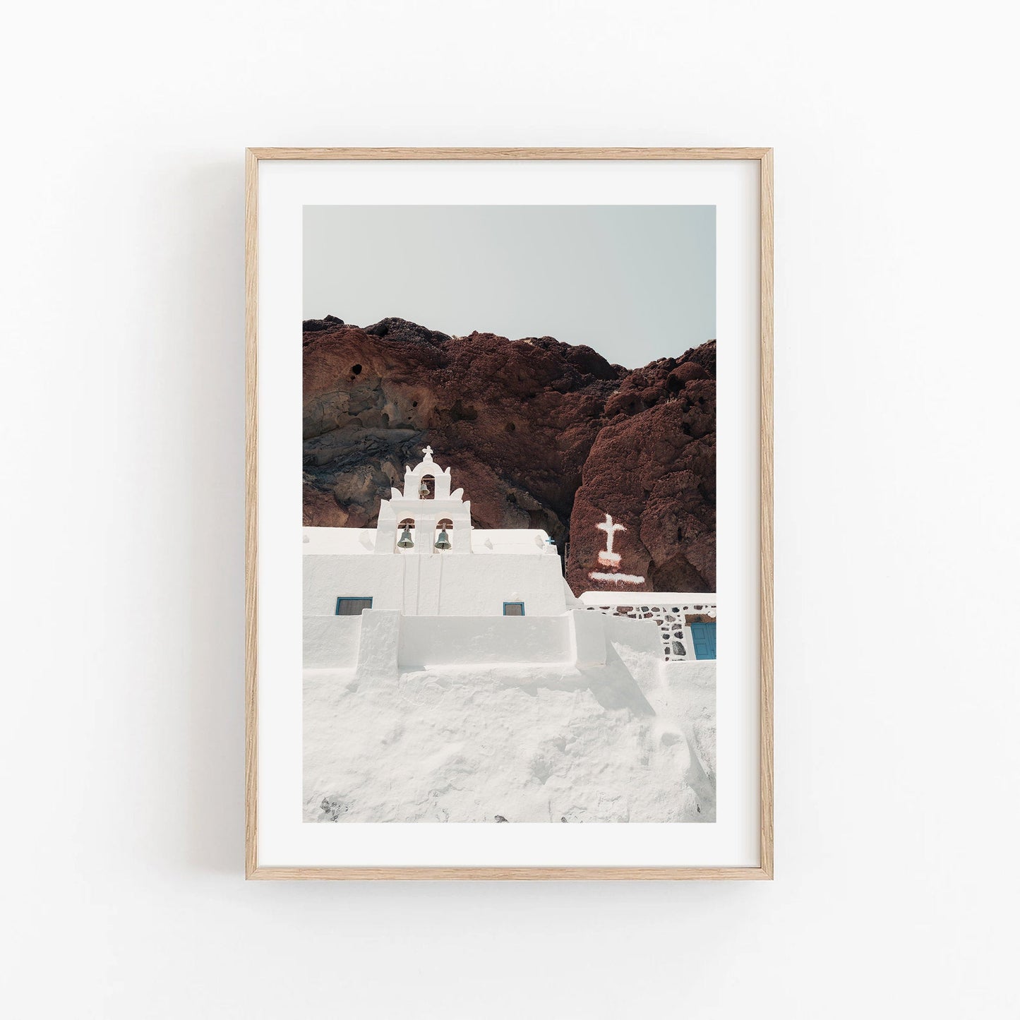 Framed photo titled Red Beach Church depicting a white church on a rocky hillside, set under a clear sky.