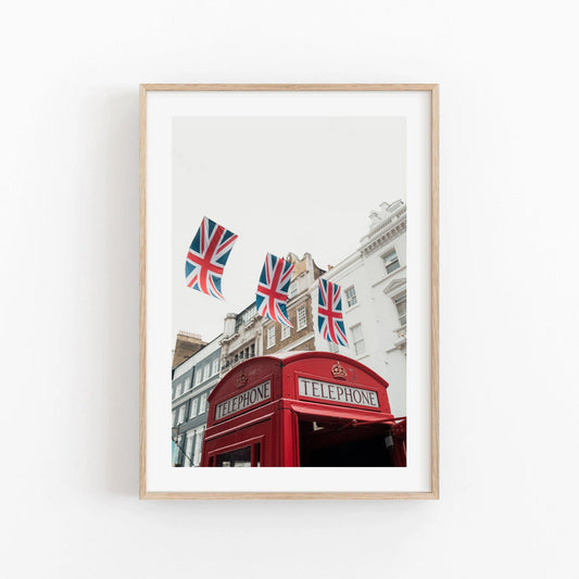 Framed photo Red Booth shows a UK telephone kiosk with Union Jack flags and historic buildings in the backdrop.