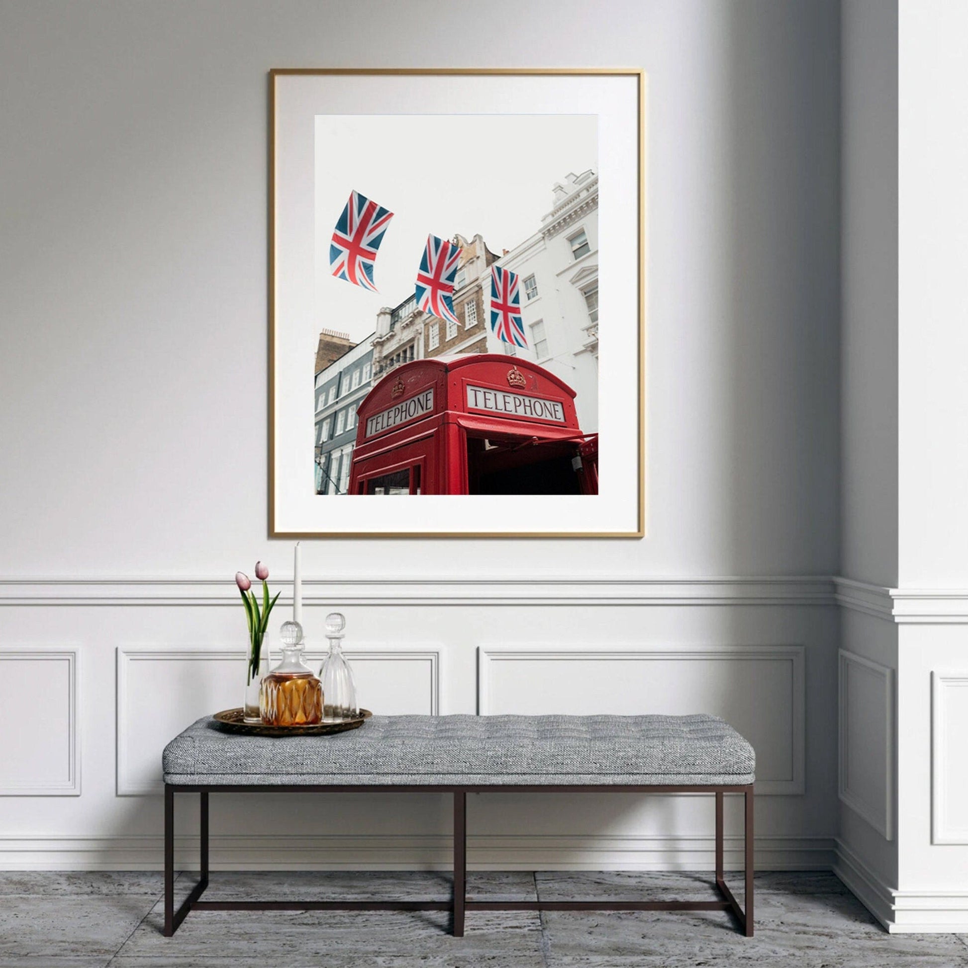 The Red Booth photo is framed above a bench with a vase and glassware in an elegant room with flags.