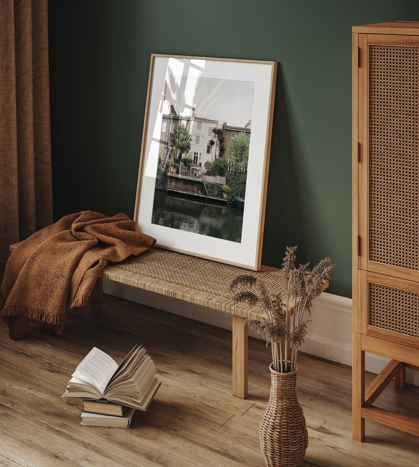 A Regents Canal photo on a woven bench with a brown blanket, open book, and dried plants nearby.