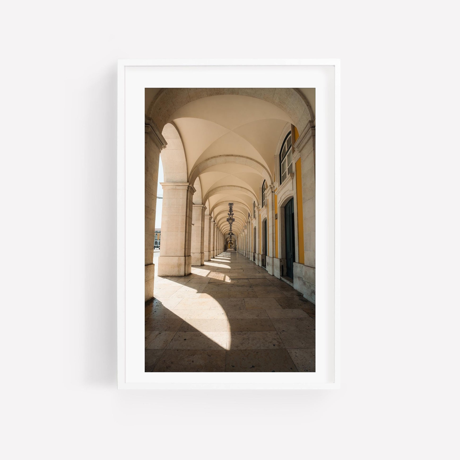Rhythmic Arches: Sunlit stone corridor with vaulted ceilings, framed in white against a plain background.