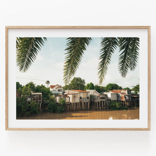 Framed photo of River Homes with palm leaves and trees in the background.