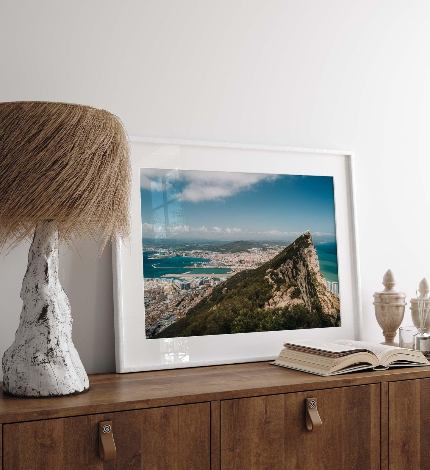 Rock of Gibraltar photo framed on a wooden side table with a rustic lamp and decorative items.