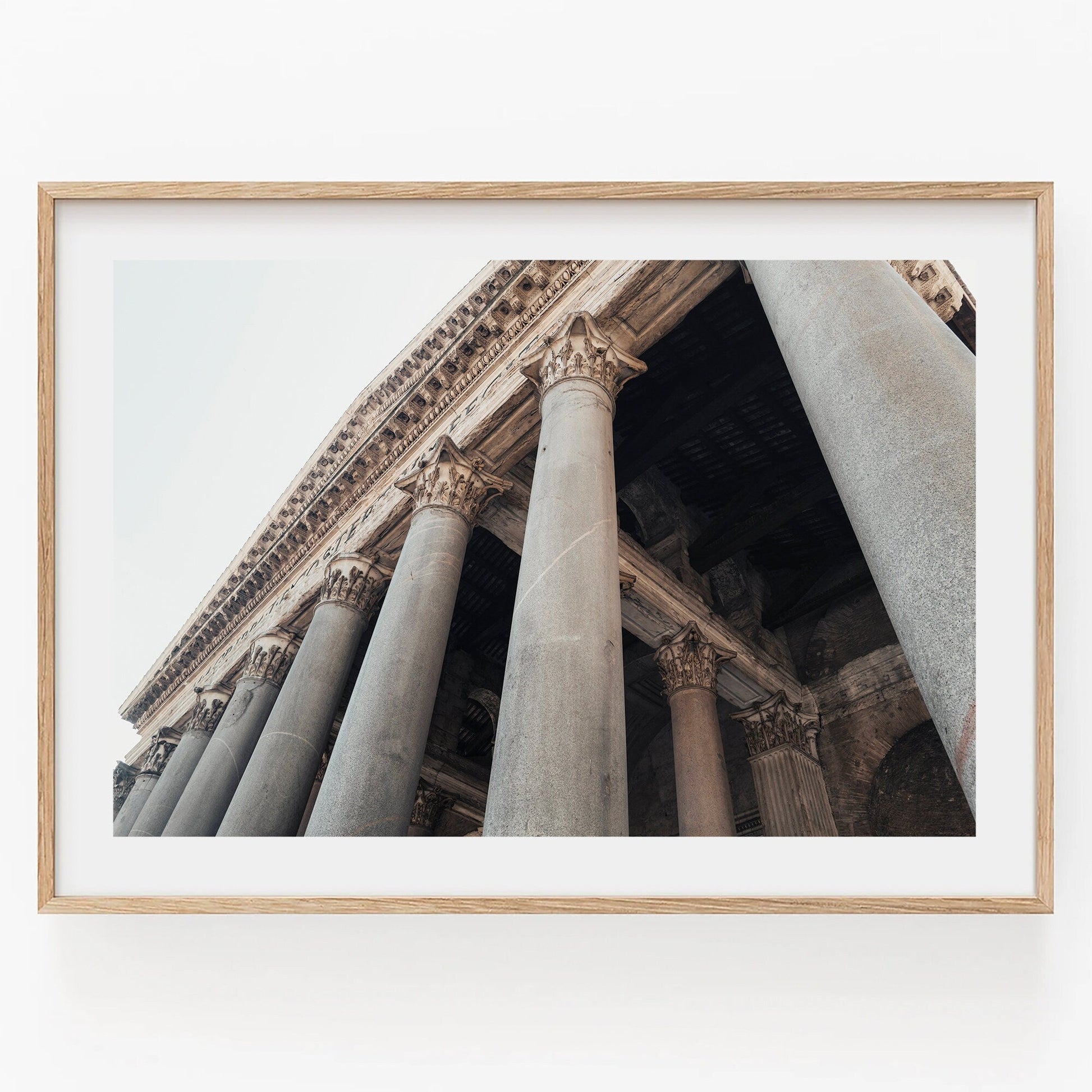Framed photo of the Roman Pantheon II captured from a low angle, showcasing tall stone columns and intricate details.